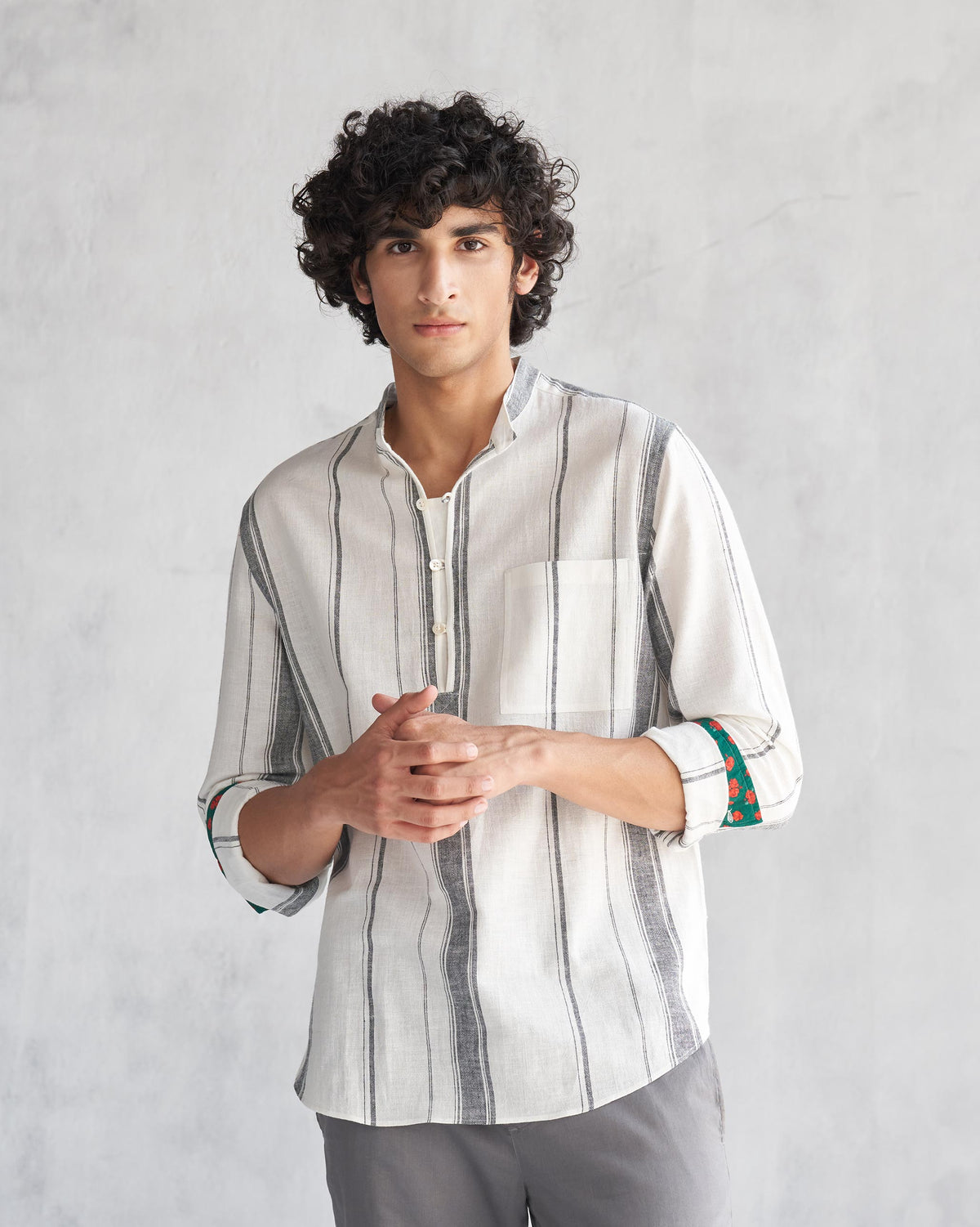 Person wearing an ivory Novac shirt with grey stripes and a chest pocket.