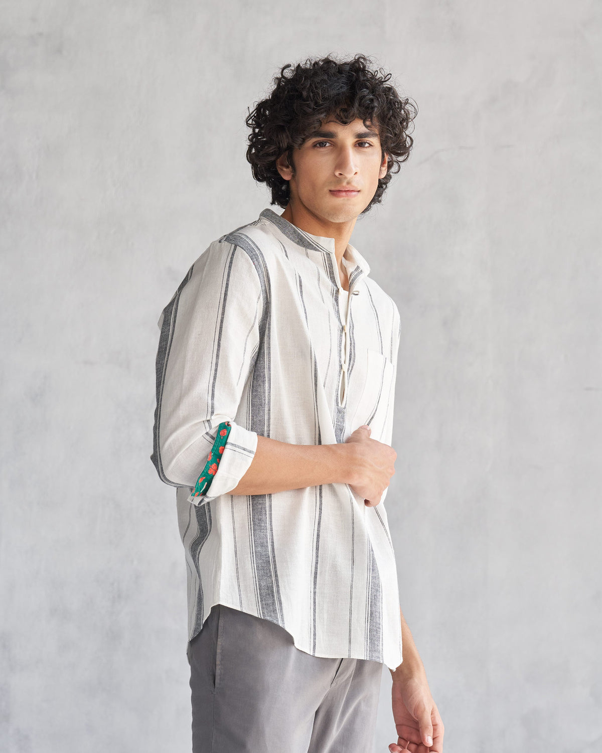 Three-quarter view of an ivory Novac shirt with grey stripes worn by a person.