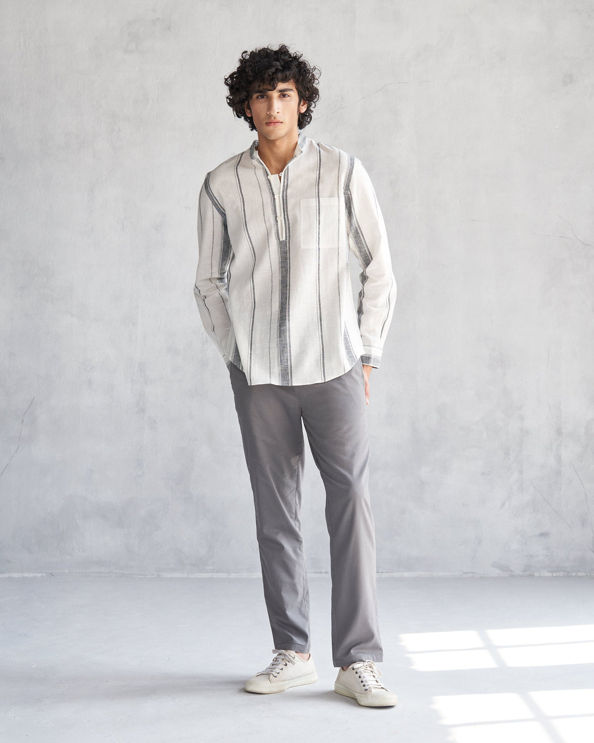 Full-length view of an ivory Novac shirt with grey stripes worn by a person.