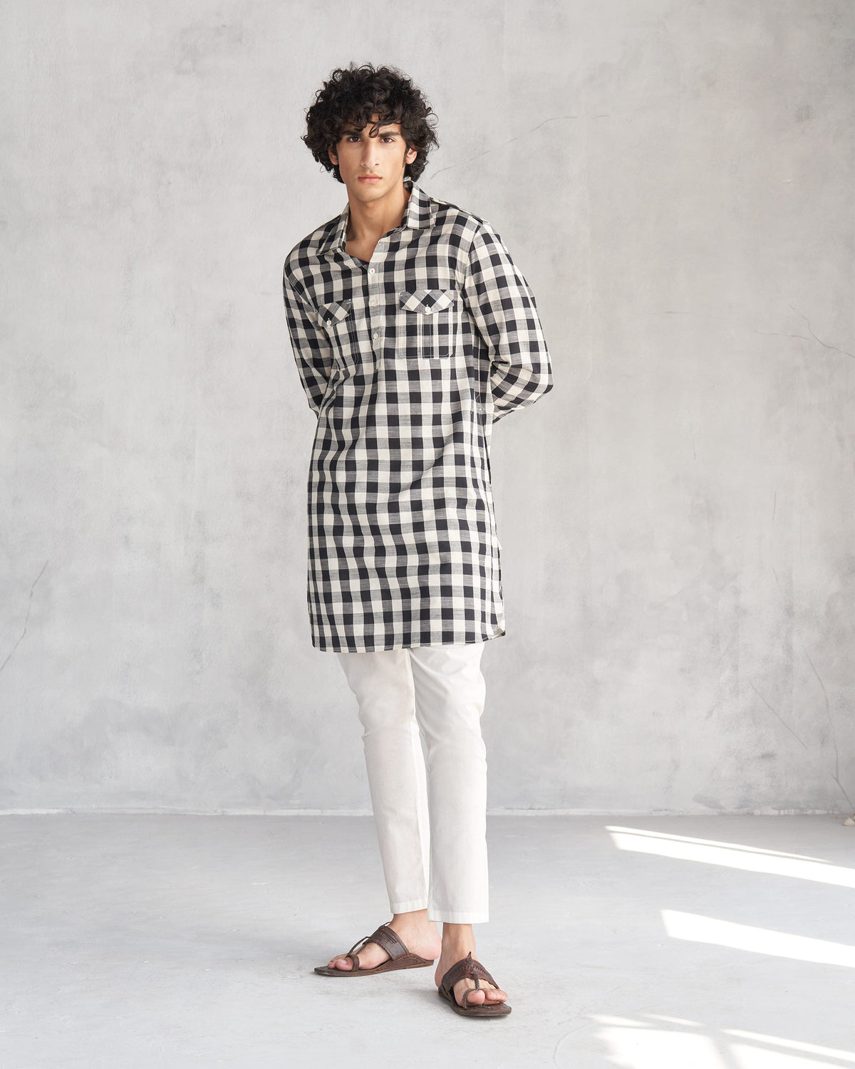 Person standing in a black and ivory checked Nizamuddin kurta.