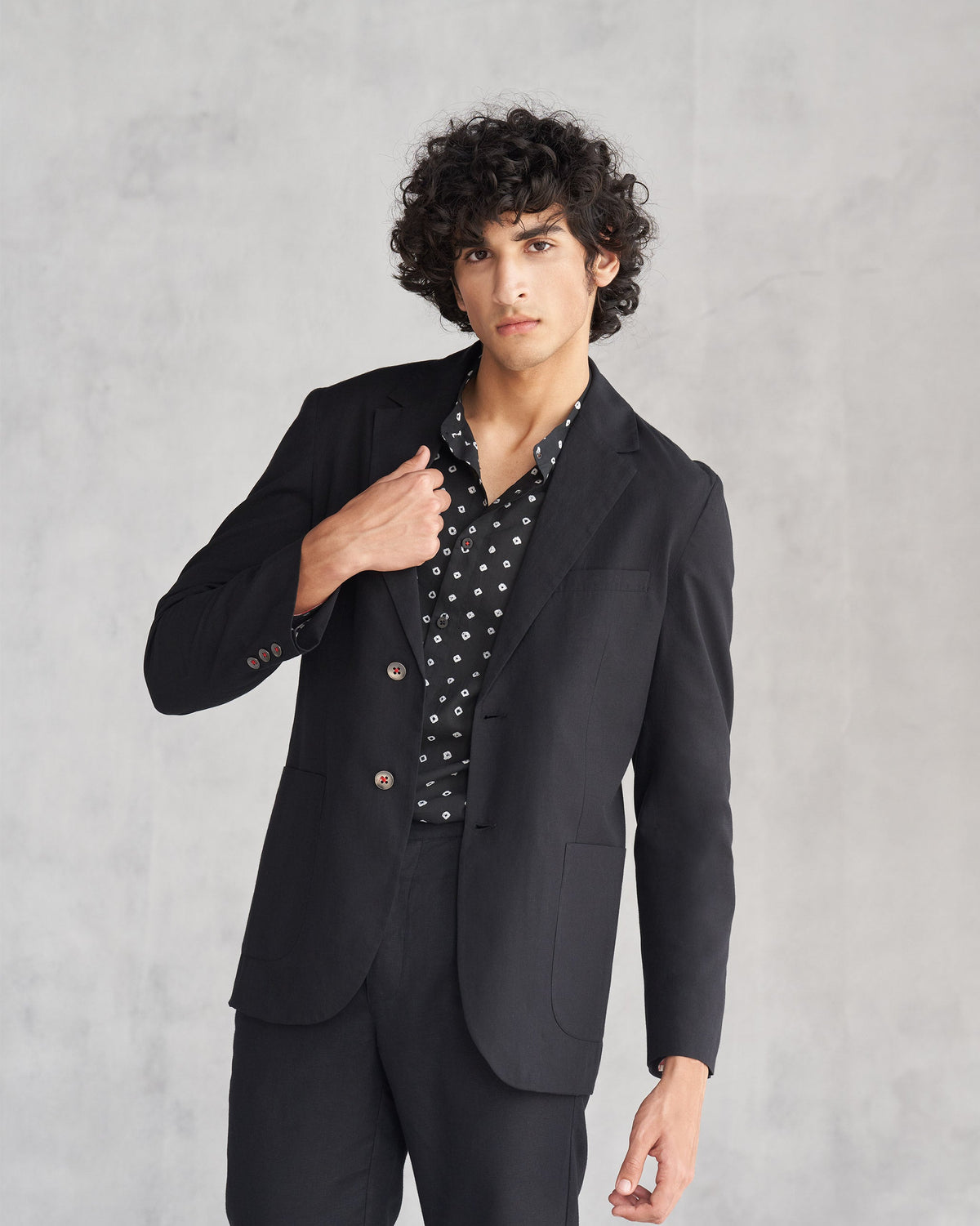Person wearing a black Midnight Marvel Jacket, one hand at the lapel.