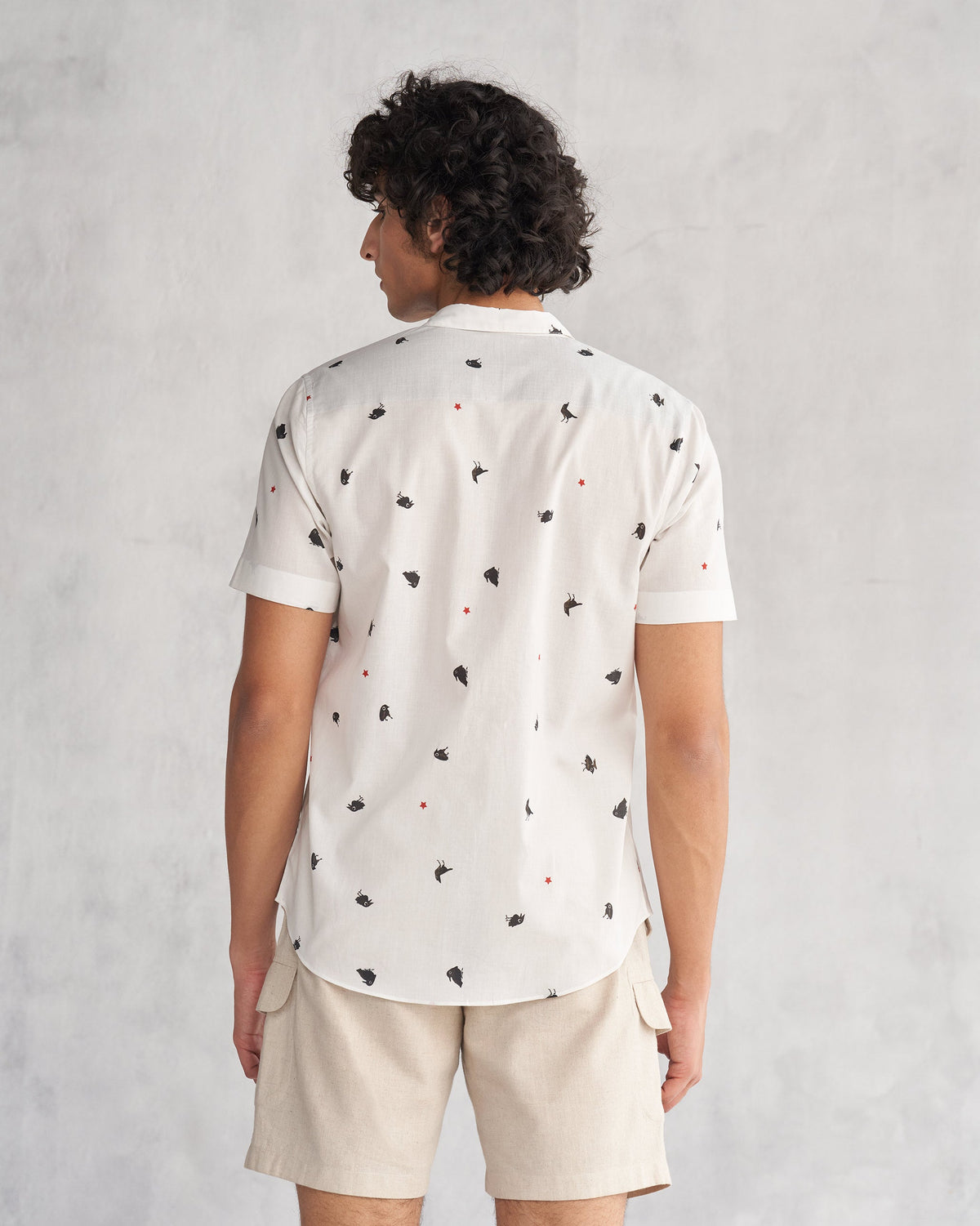 Back of the Riverine Shirt worn by a person, with small black motifs.