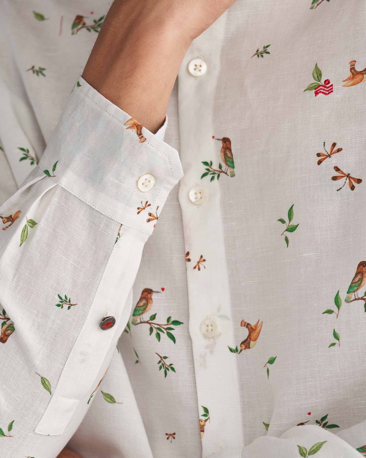 Close-up of a white Nawab Shirt sleeve with a bird and leaf print.