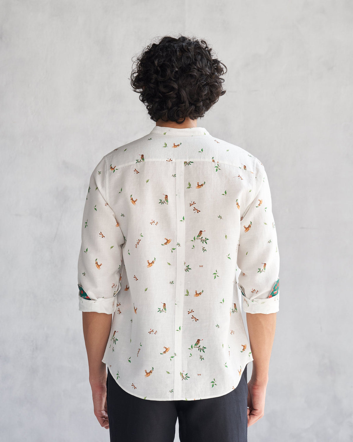 Back of a white Nawab Shirt with a bird and leaf print worn by a person.
