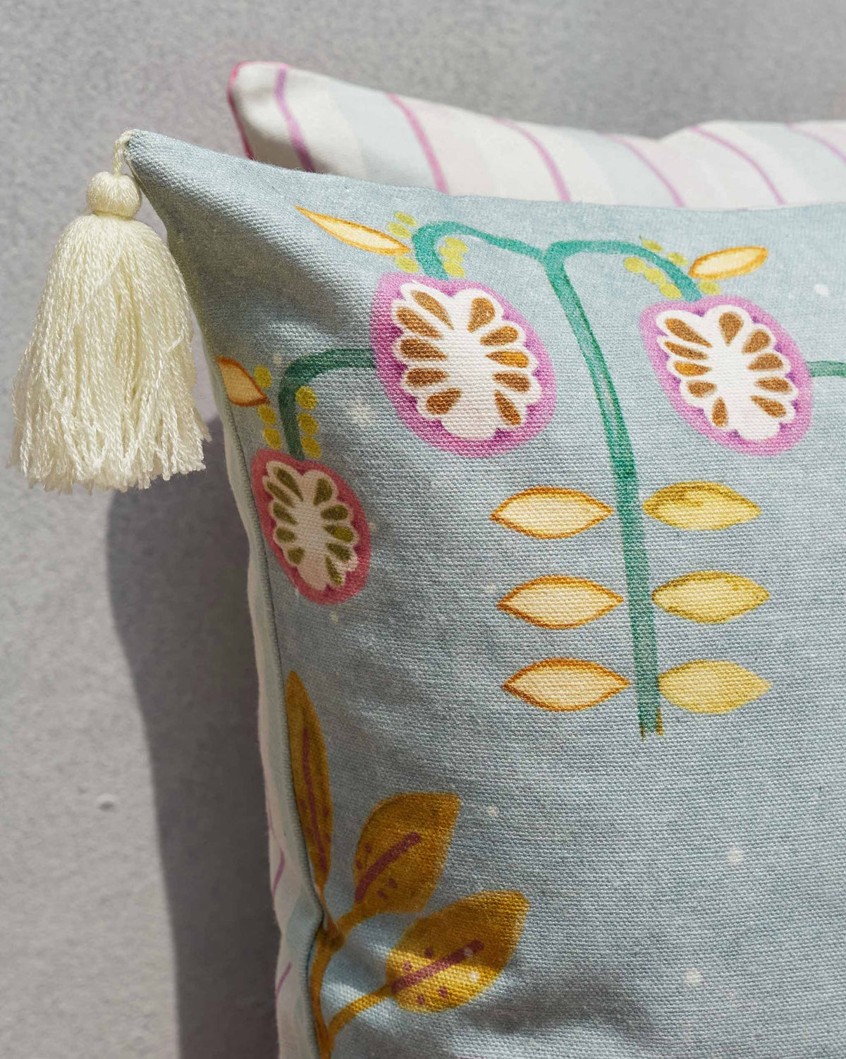 Corner of a Zebra Cushion Cover showing a cream tassel and printed flowers.