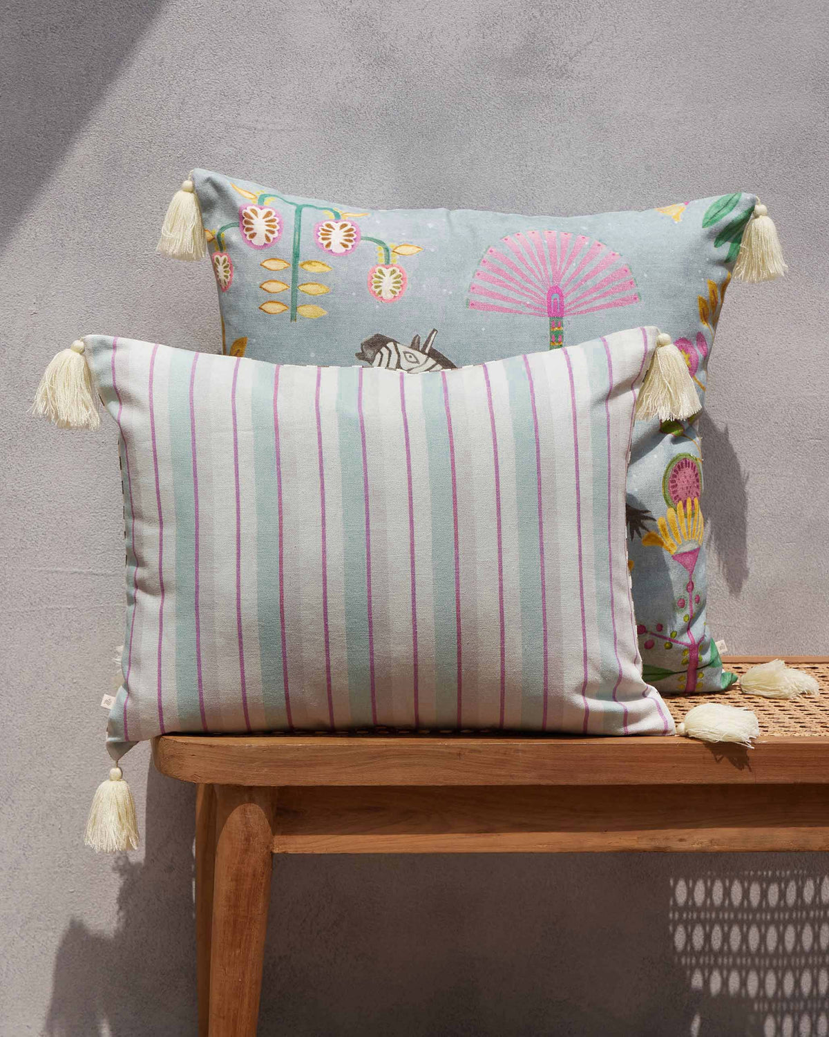 Bahari Lumbar Cushion Cover in pink, green and cream stripes, with tassels.