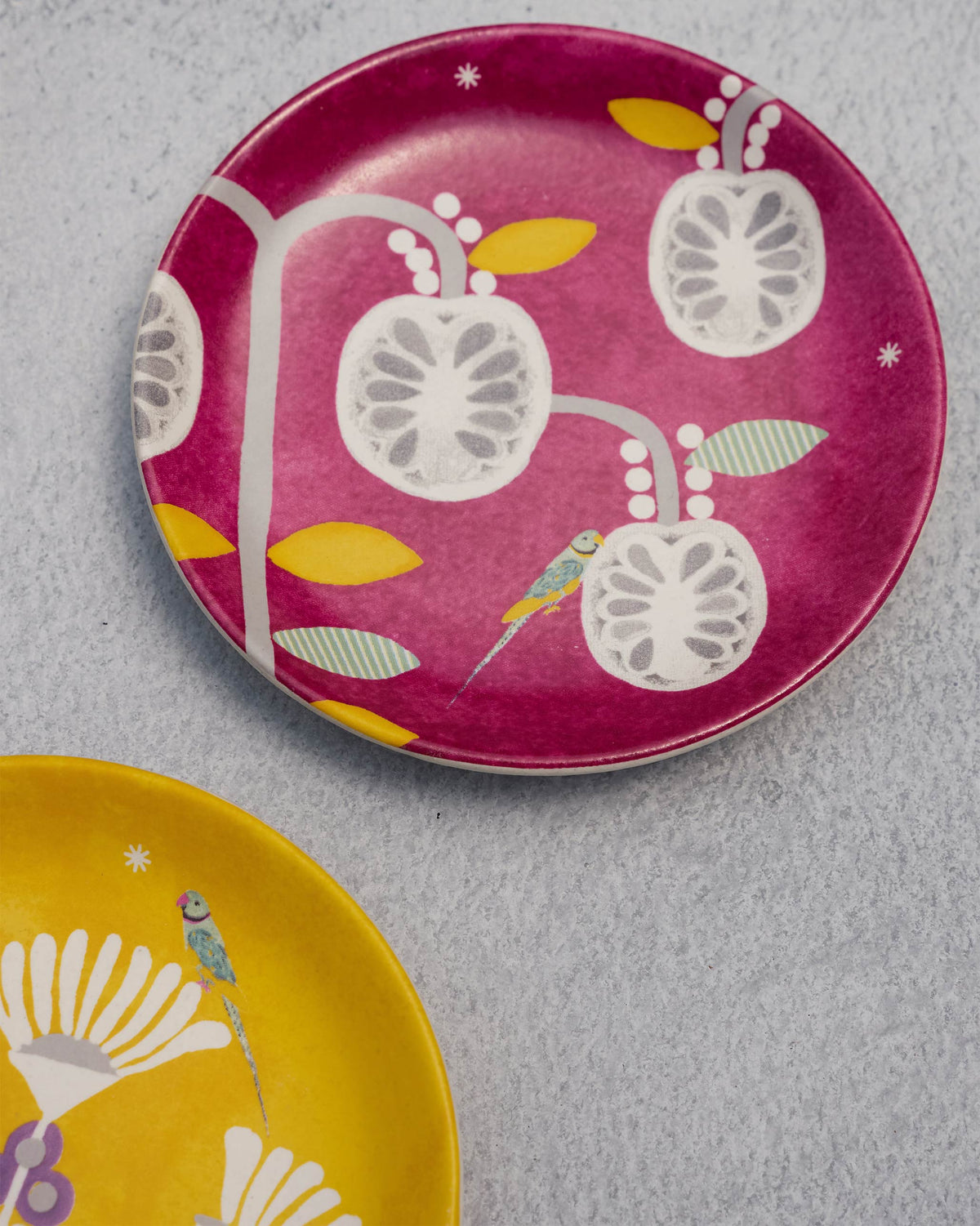 Pink Bahari tea plate with white fruit motifs and a small bird.