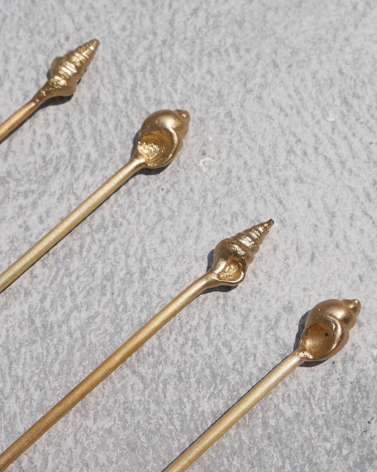 Close-up of the Seashells stirrer ends showing ridged shell-shaped tips.