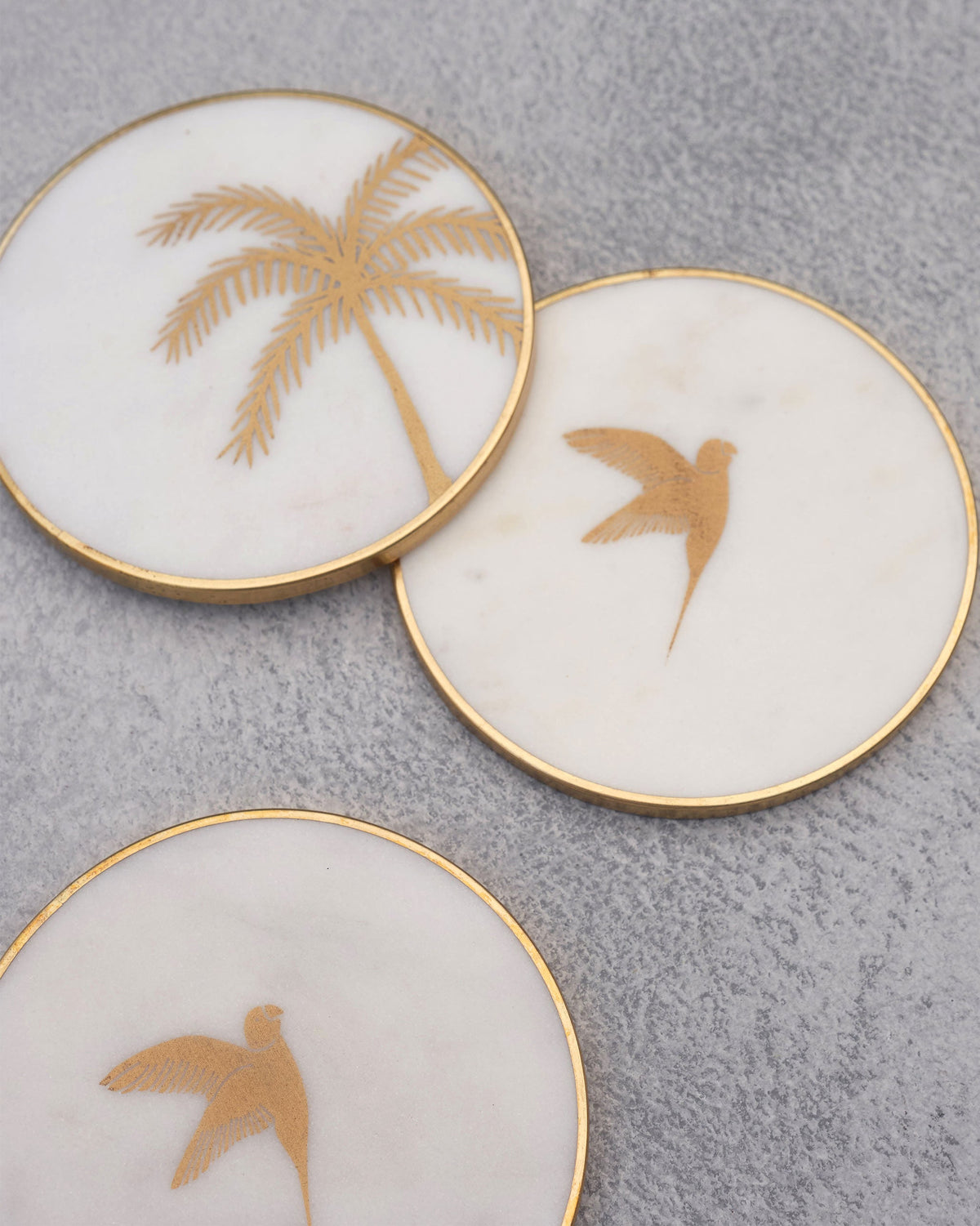 Close-up of Coastline coasters showing a gold palm tree and birds.