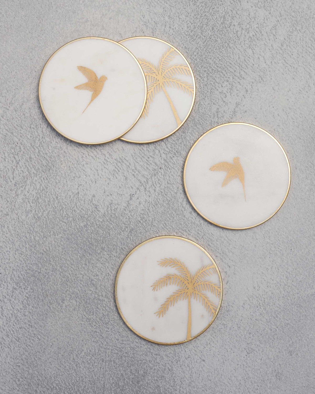 Coastline coasters arranged in a loose group, two with birds and two with palms.