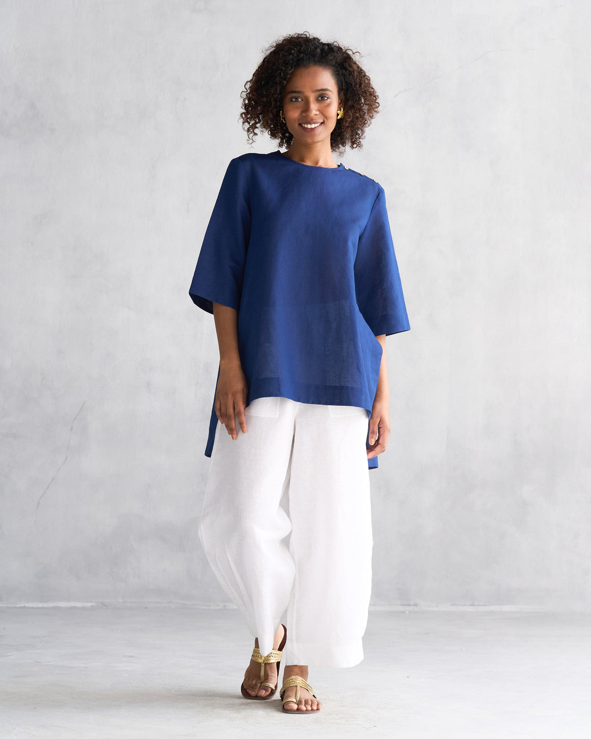 Person wearing white Serene pants with a navy high-low tunic.