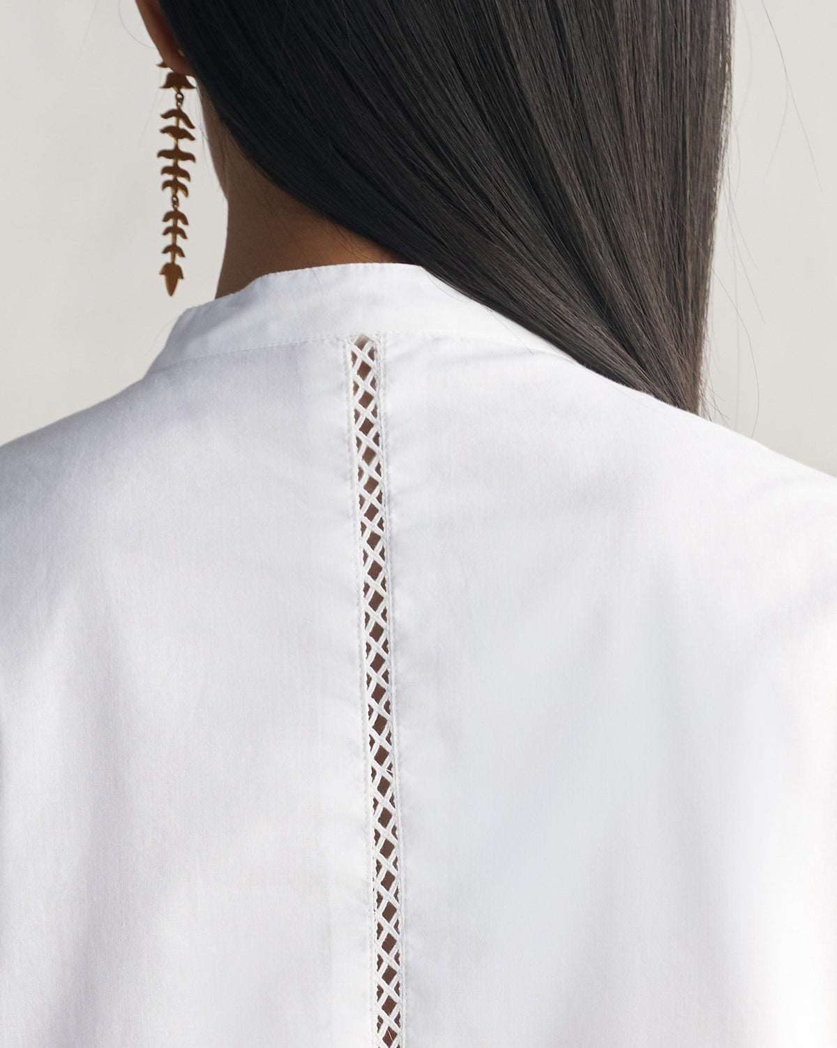Back of a white Waist Gathered Kurta with a lattice cutwork strip down the centre back.