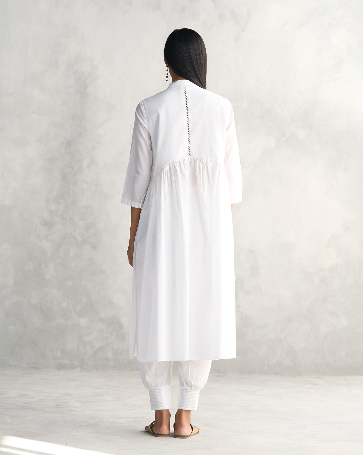 Back of a white Waist Gathered Kurta worn by a person, showing its gathered skirt.