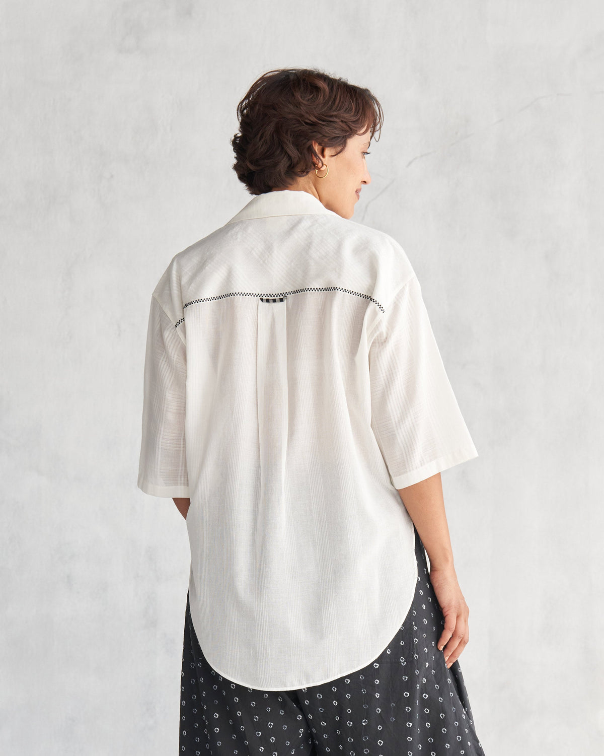 Back of an ivory Naomi shirt worn by a person.