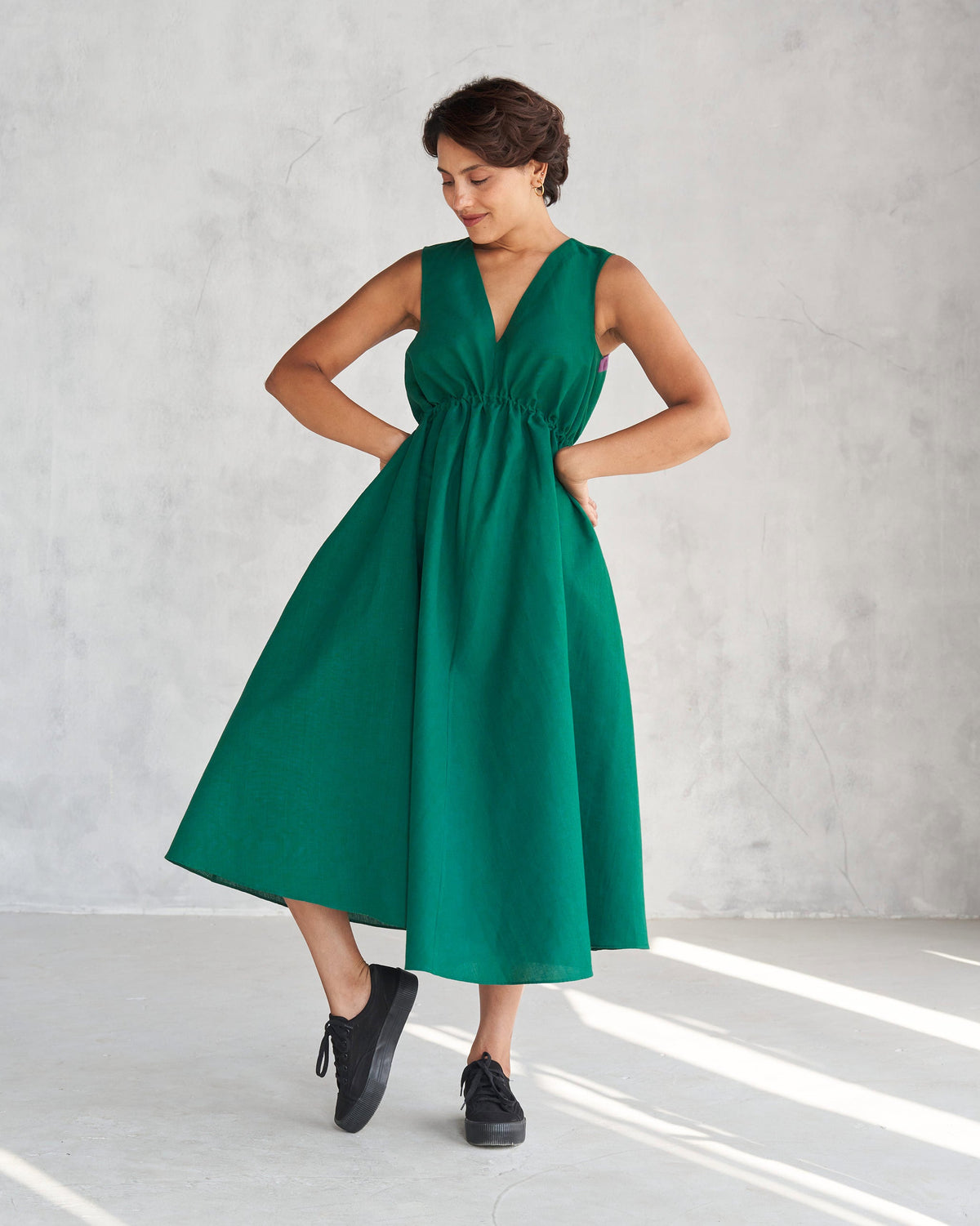 Person wearing a green Midori dress with a V-neck and drawstring waist.