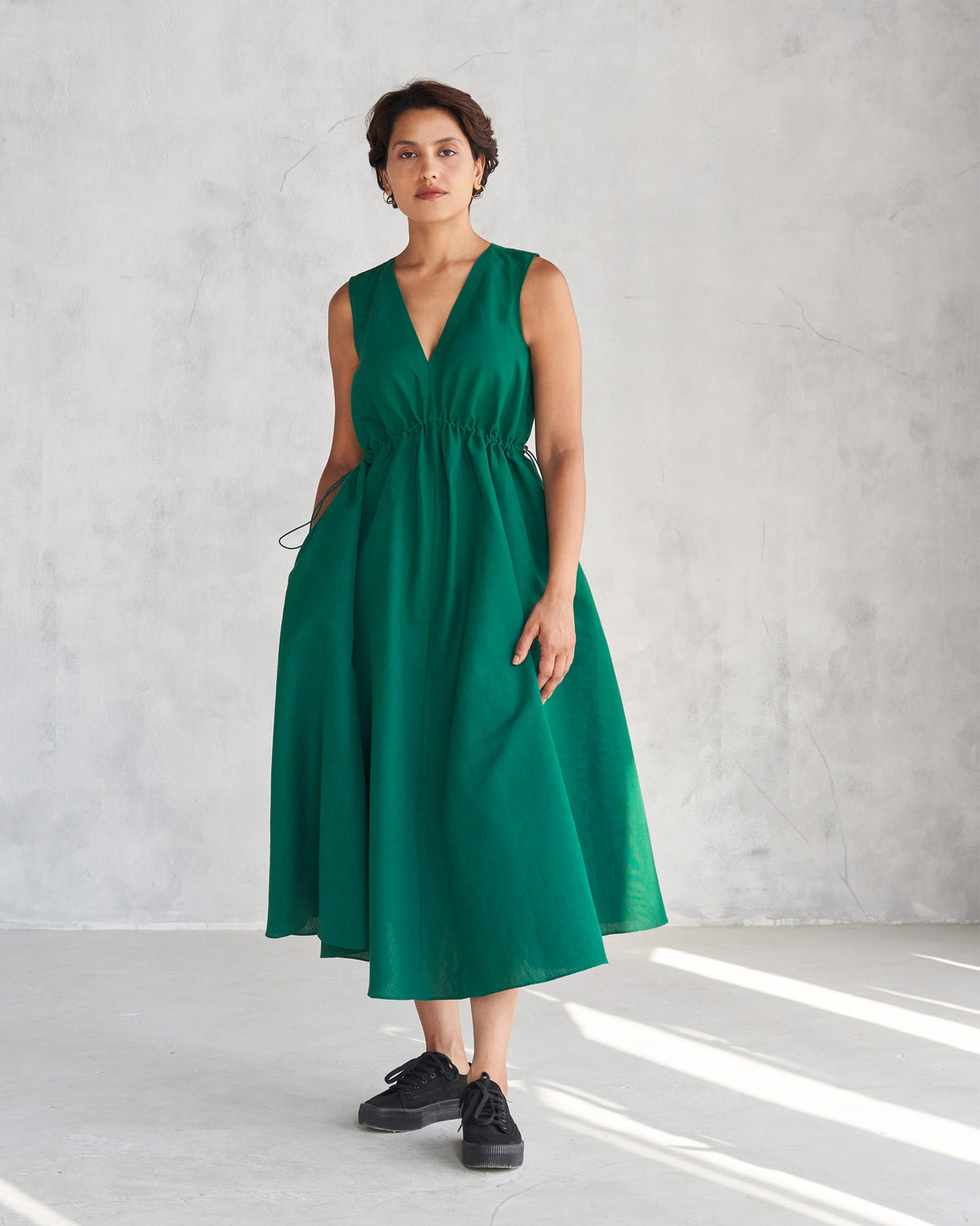 Person wearing a green Midori dress with a flared midi skirt.