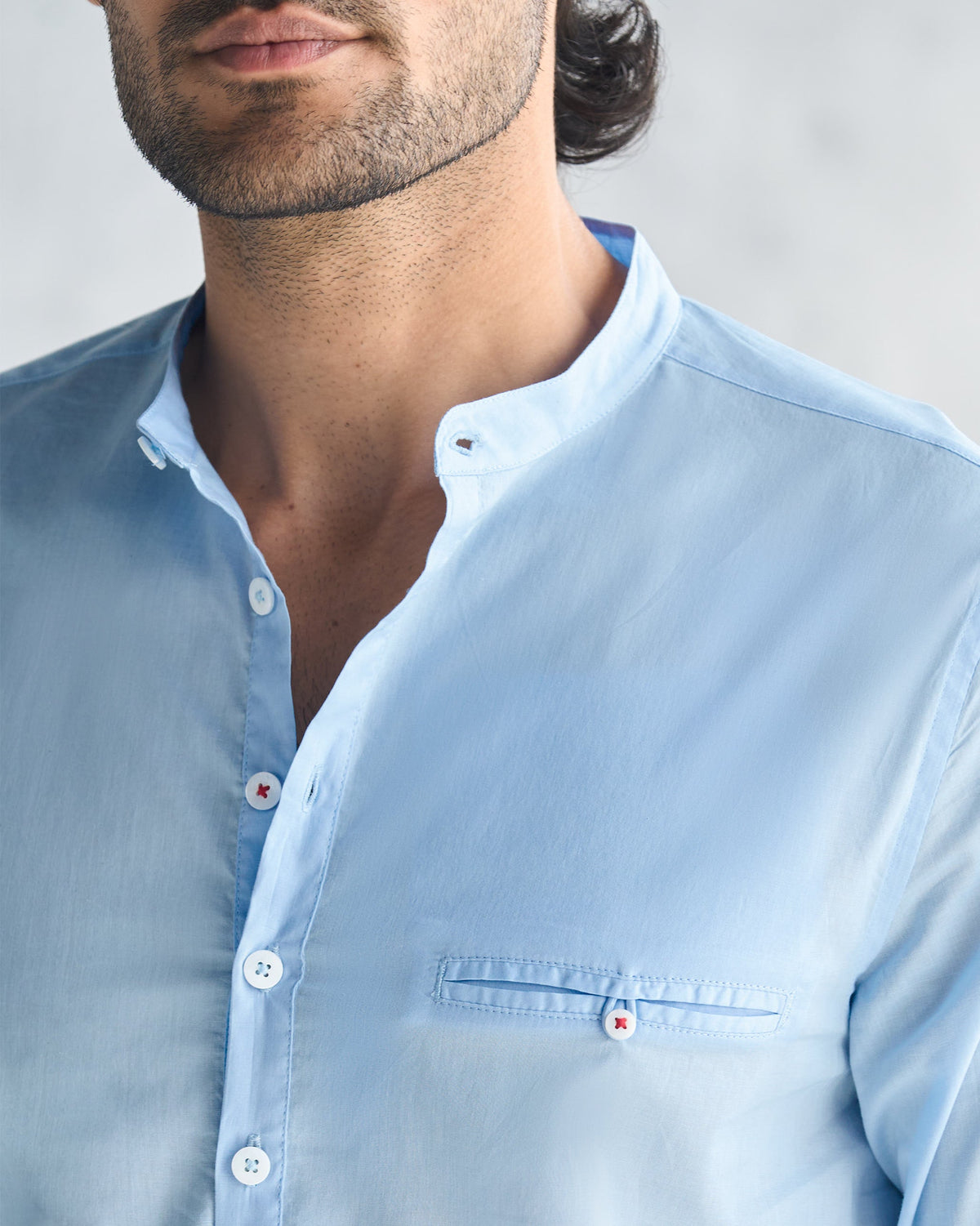 Close-up of a light blue Pondicherry shirt showing collar and chest pocket.