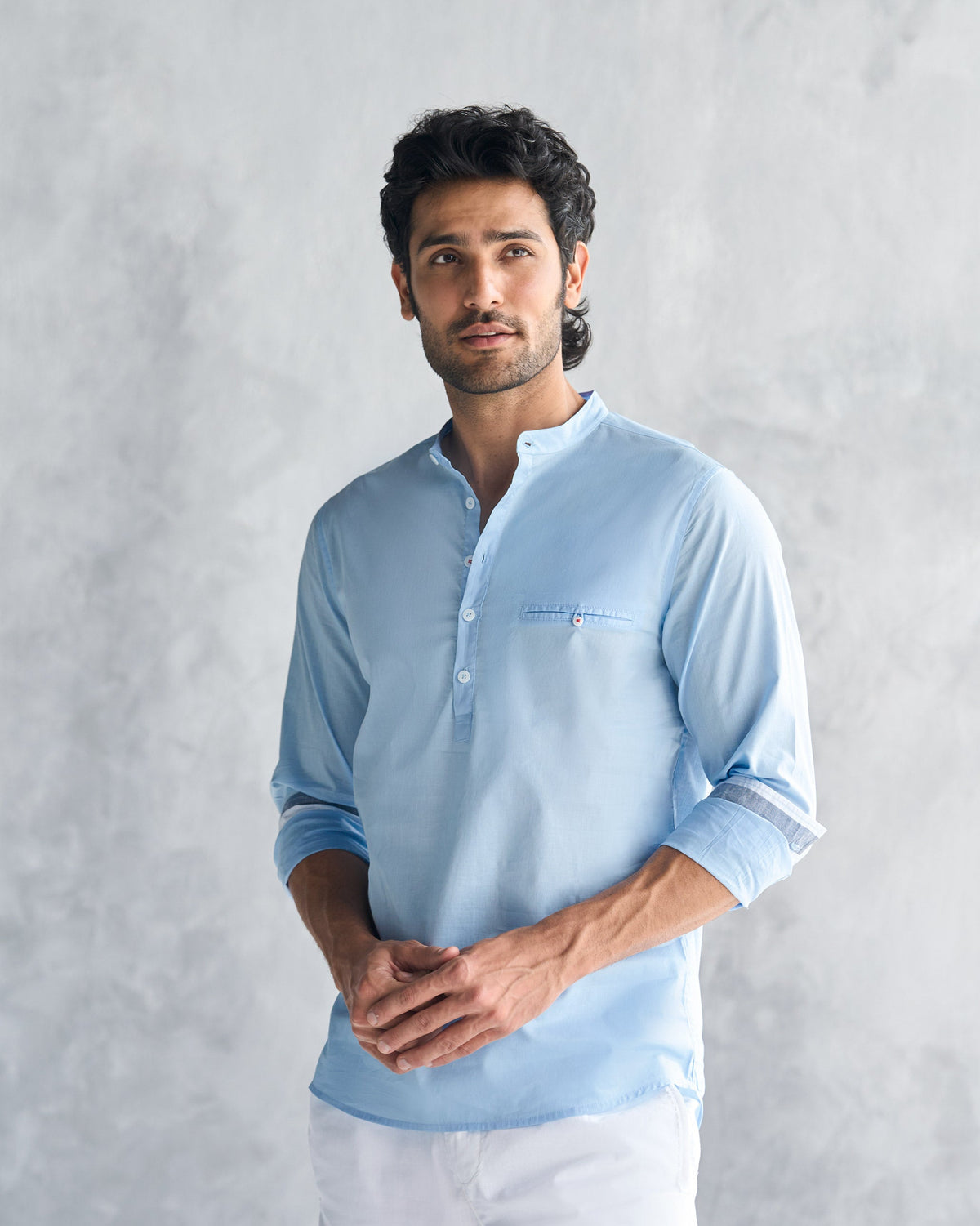 Person wearing a light blue Pondicherry shirt with mandarin collar and chest pocket.