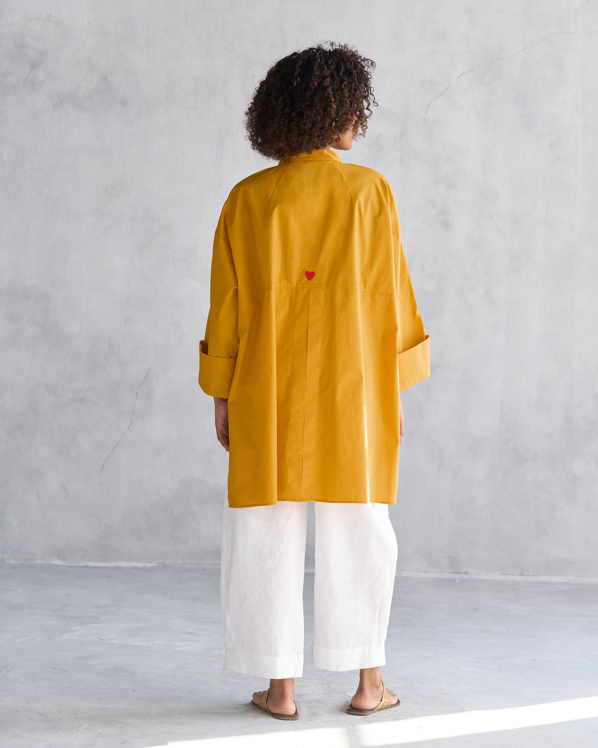 Back of Cirrus Shirt worn by a person, with a small red heart embroidery.