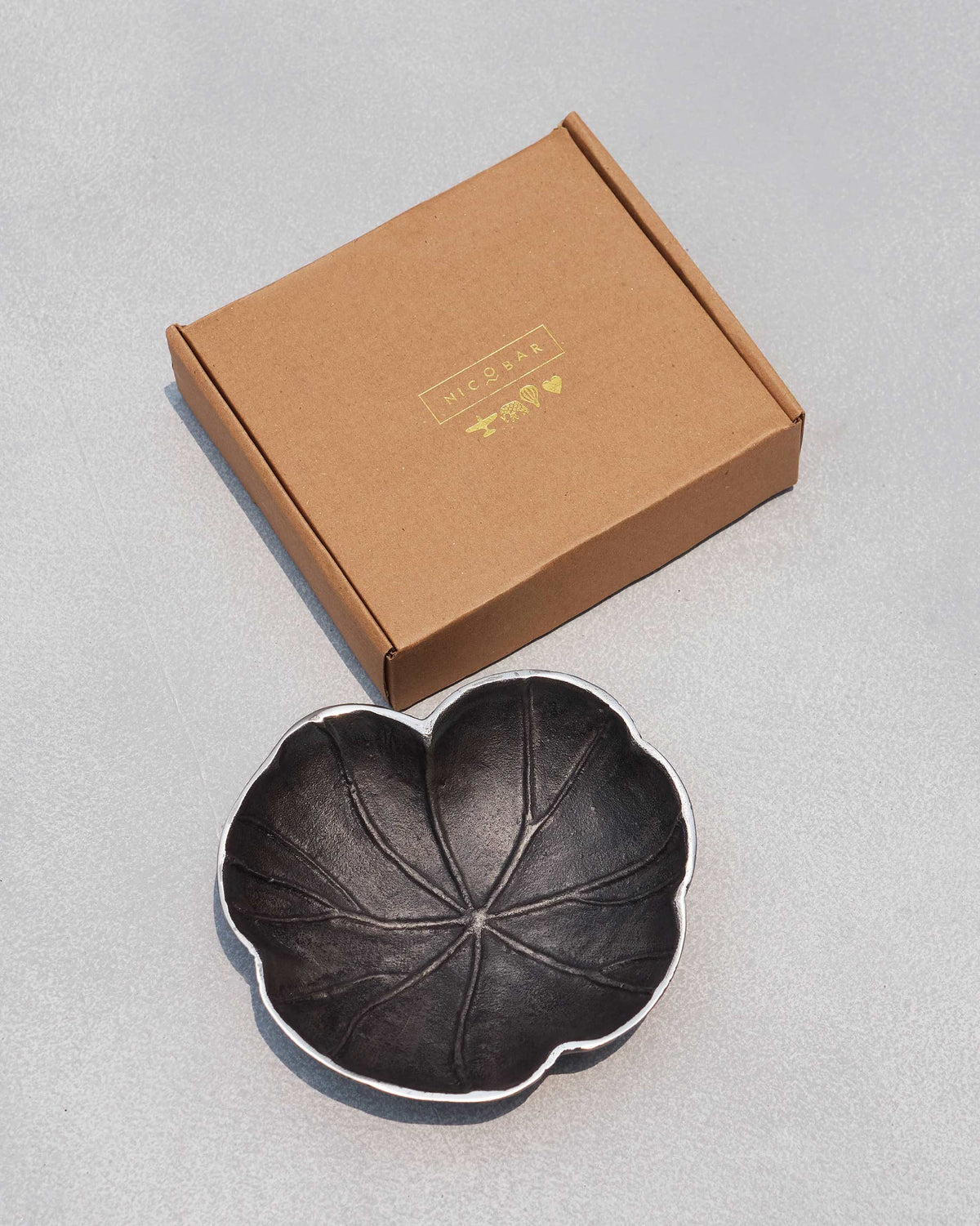 Kamal Leaf Trinket Tray beside a brown Nicobar box with gold lettering.