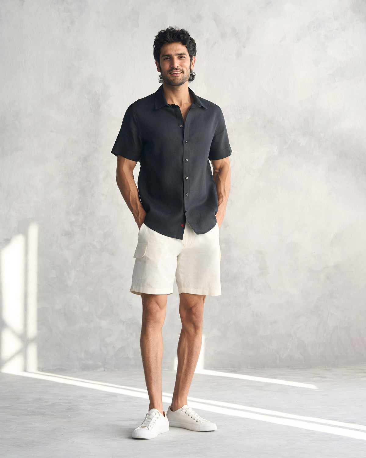Person wearing a black half sleeve shirt untucked.