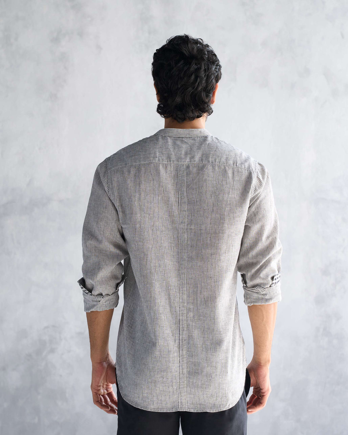 Back of a charcoal stripe Nawab shirt worn by a person.