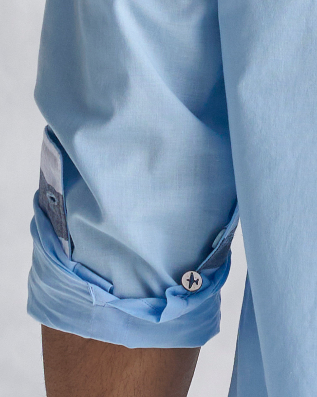 Light blue classic shirt sleeve with a striped cuff lining.