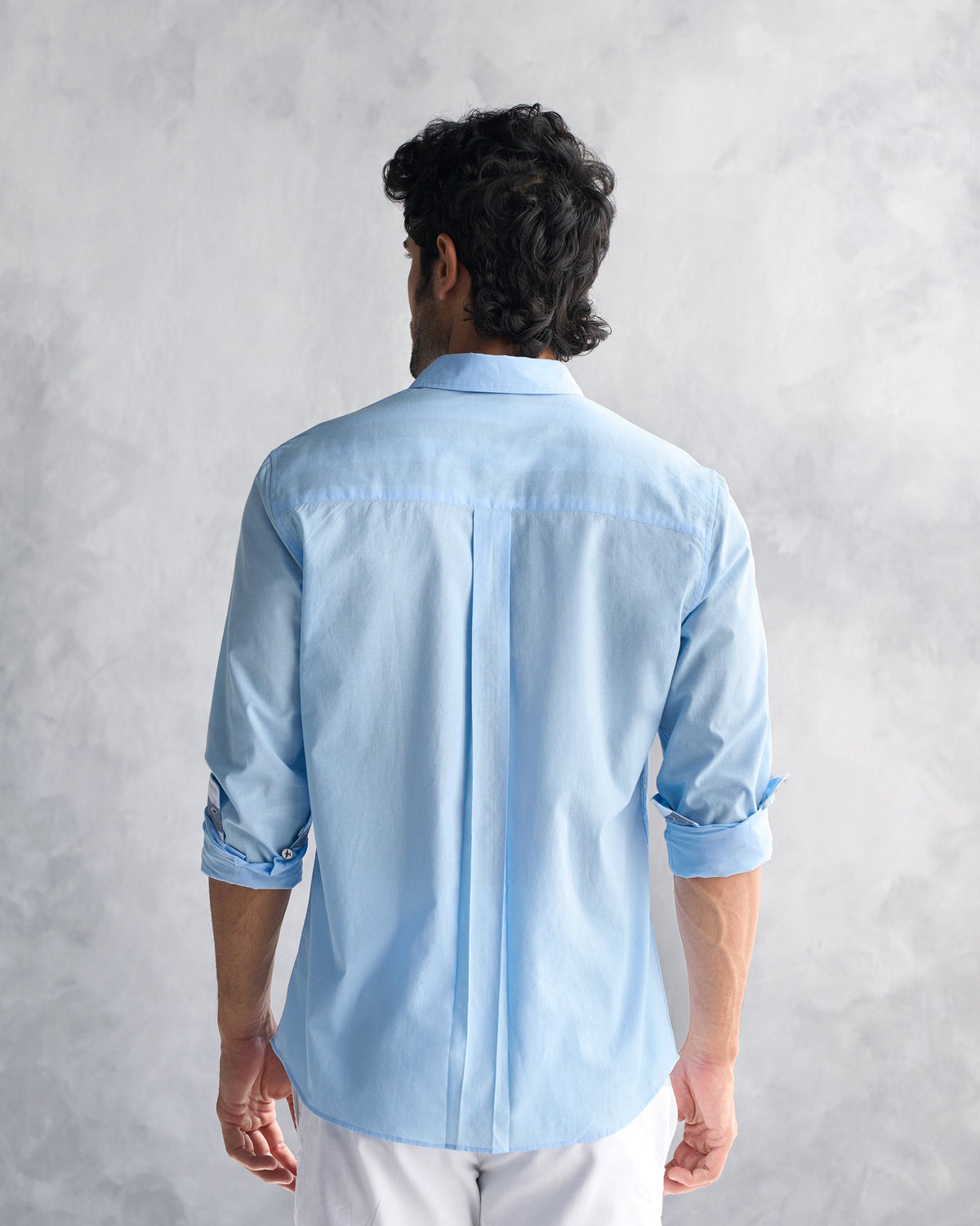 Back of a light blue classic shirt with a center box pleat.