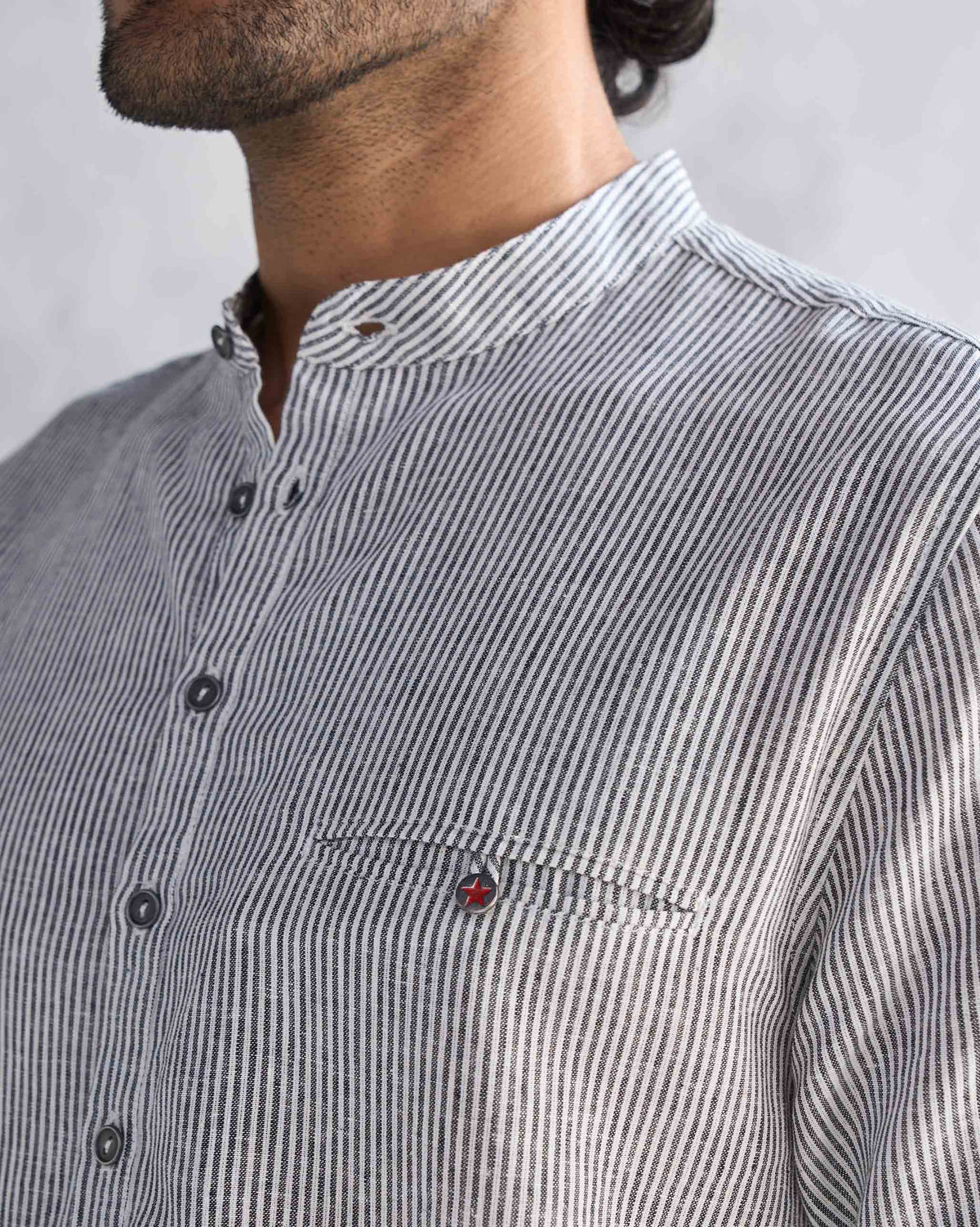 Close-up of the Pondicherry Kurta's band collar and pocket, with a small red detail.