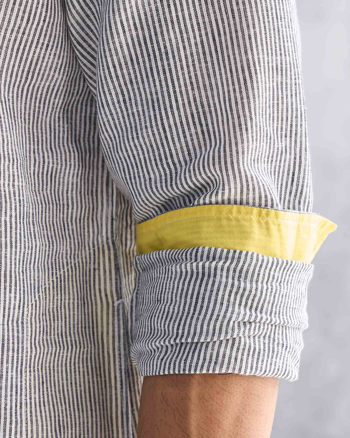 Close-up of the Pondicherry Kurta's rolled sleeve, showing yellow cuff lining.