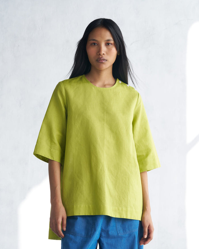 Person wearing a lime High slit top with three-quarter sleeves.