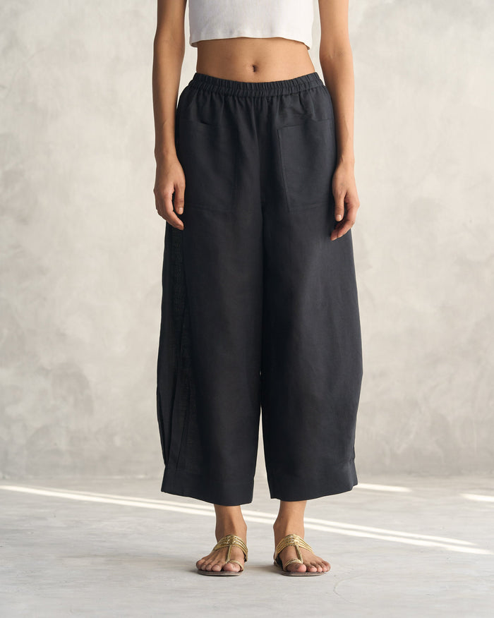 Person wearing black Serene pants with wide legs and patch pockets.