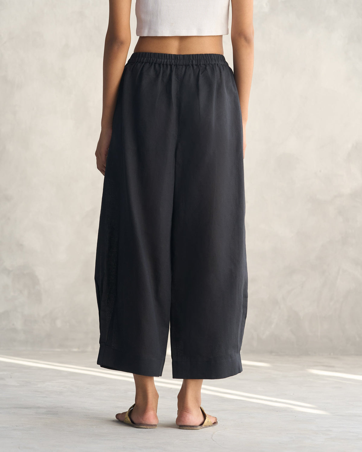 Back of black Serene pants worn by a person.