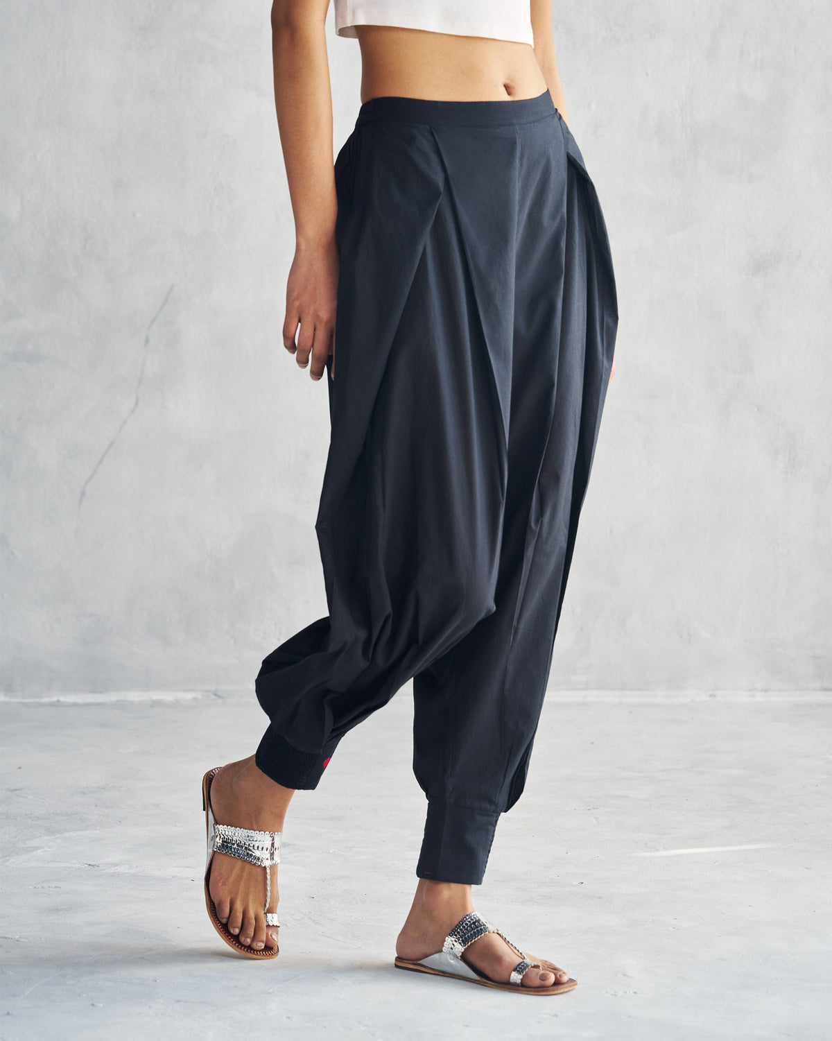 Side view of black Puff Pants with a draped, tapered leg.