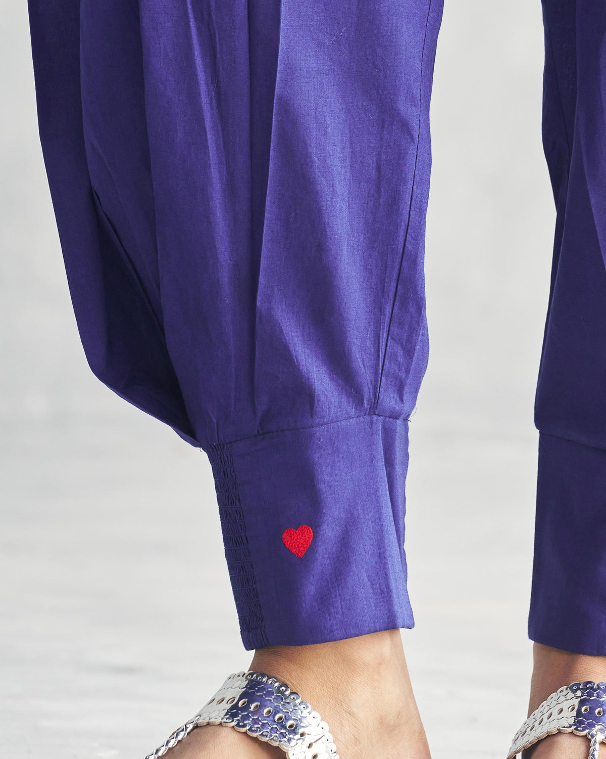 Close-up of a purple Puff Pants cuff with a small red embroidered heart.