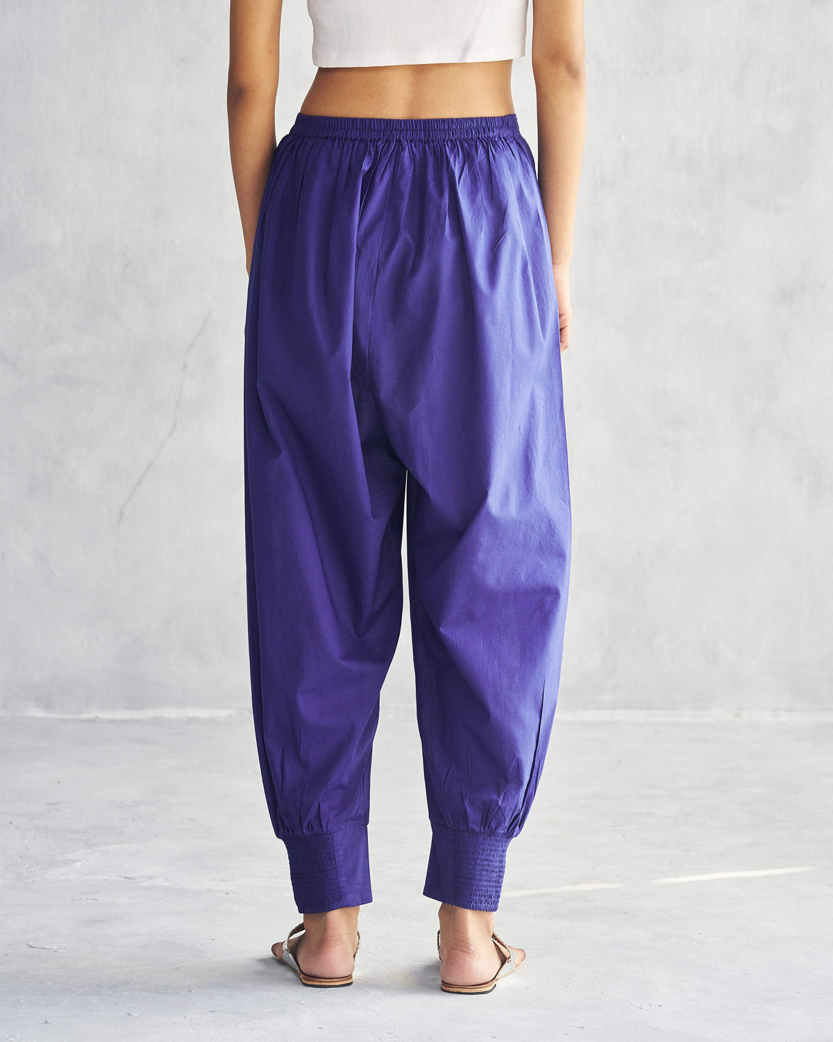 Back of purple Puff Pants with smocked cuffs worn by a person.