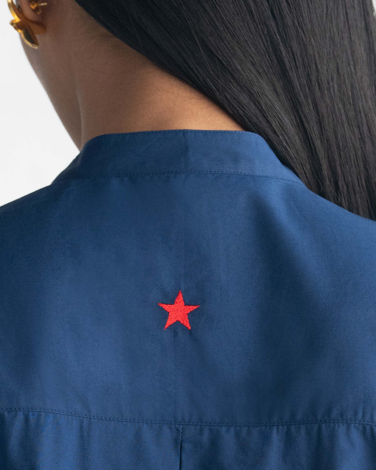 Close-up of the indigo Pema Top back collar with a red star embroidery.