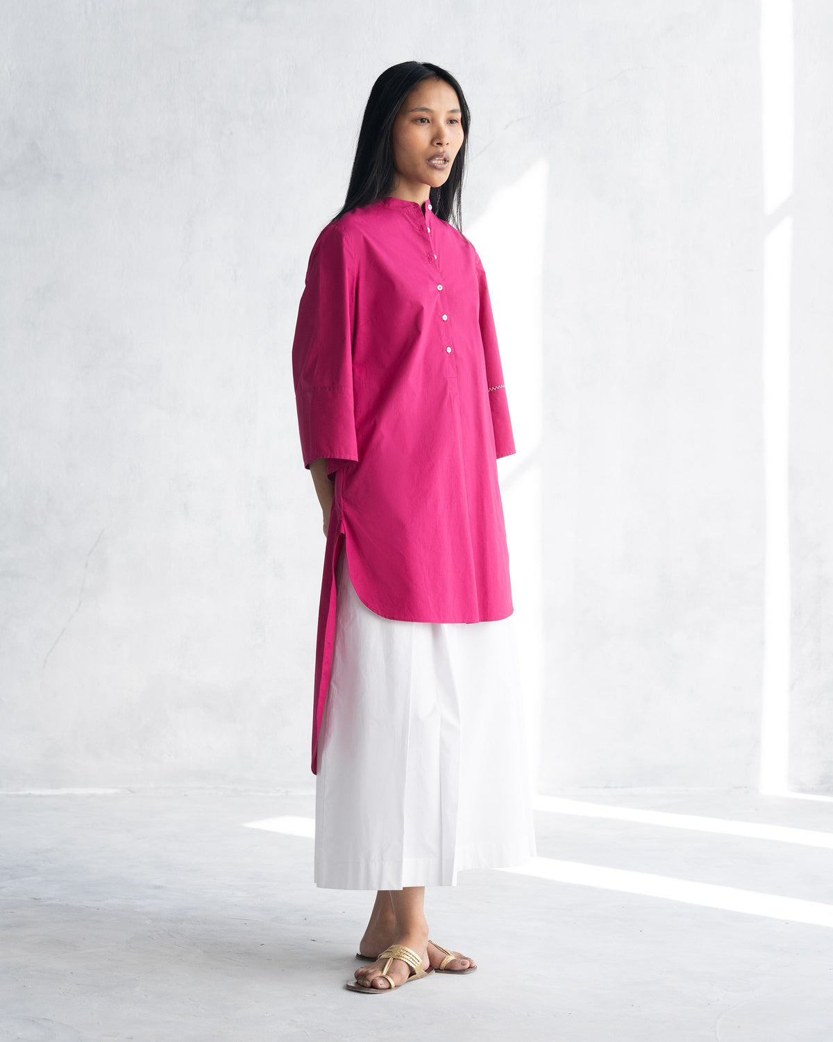 Side view of a berry Pema Top showing its high-low hem.