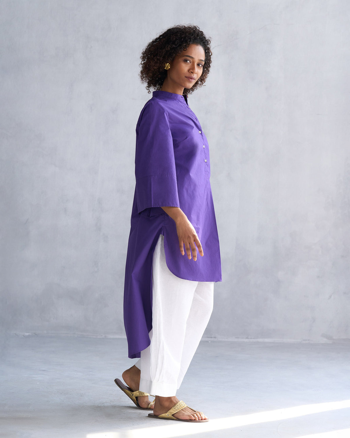 Side view of a purple Pema top with a band collar and a high-low hem.