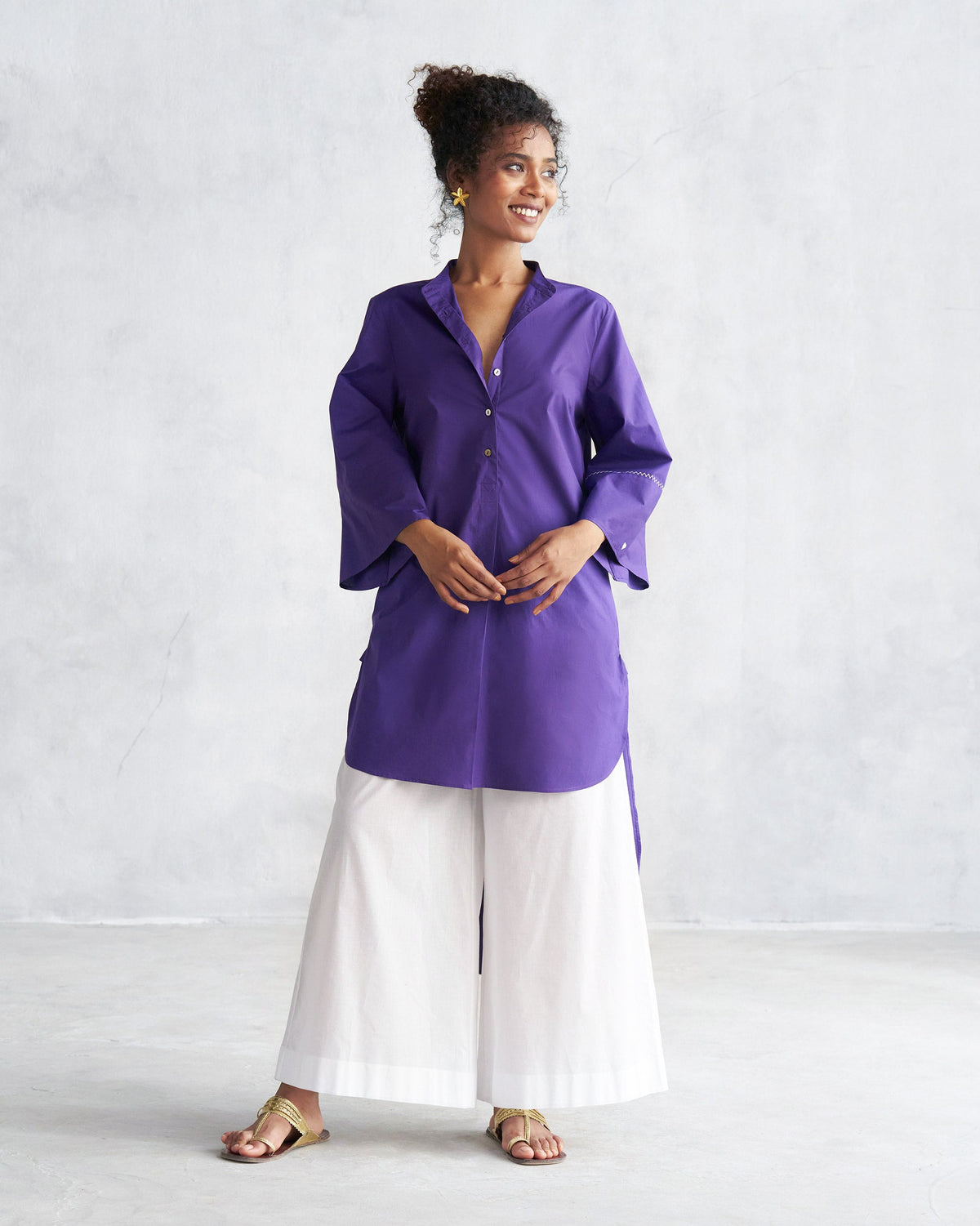 Person wearing a purple Pema top with flared three-quarter sleeves, shown full-length.