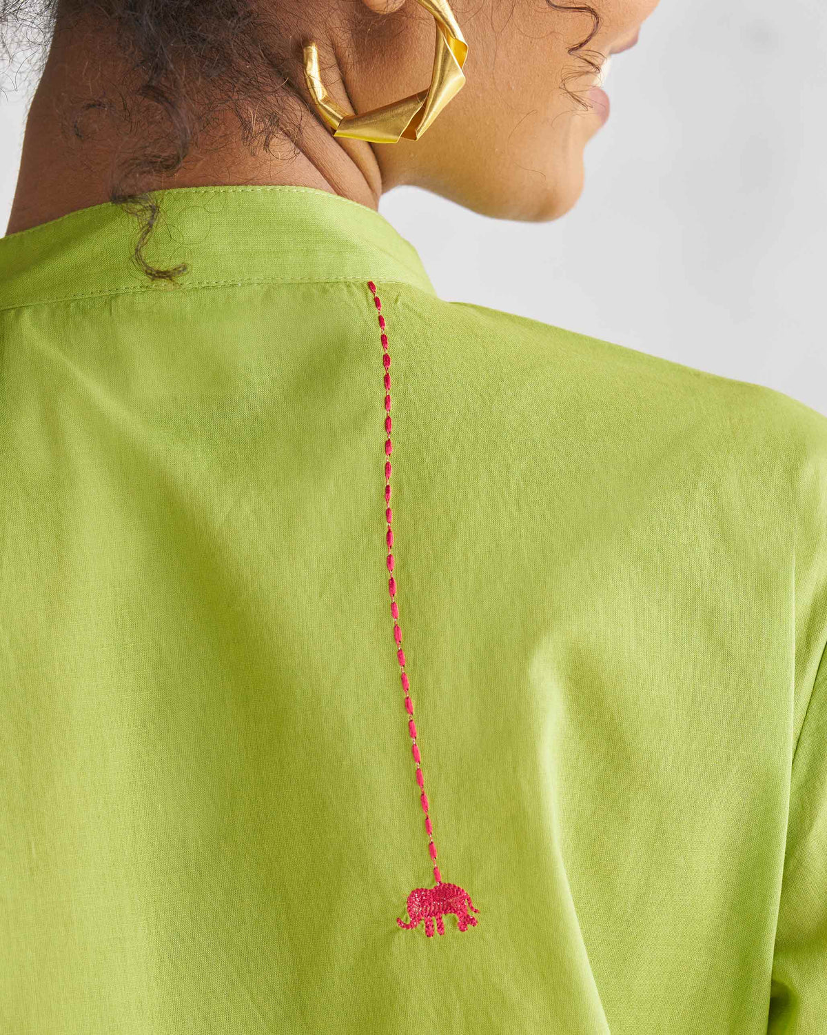 Close-up of a lime Basic Mid Length Kurta back showing a pink stitched line ending in an elephant.