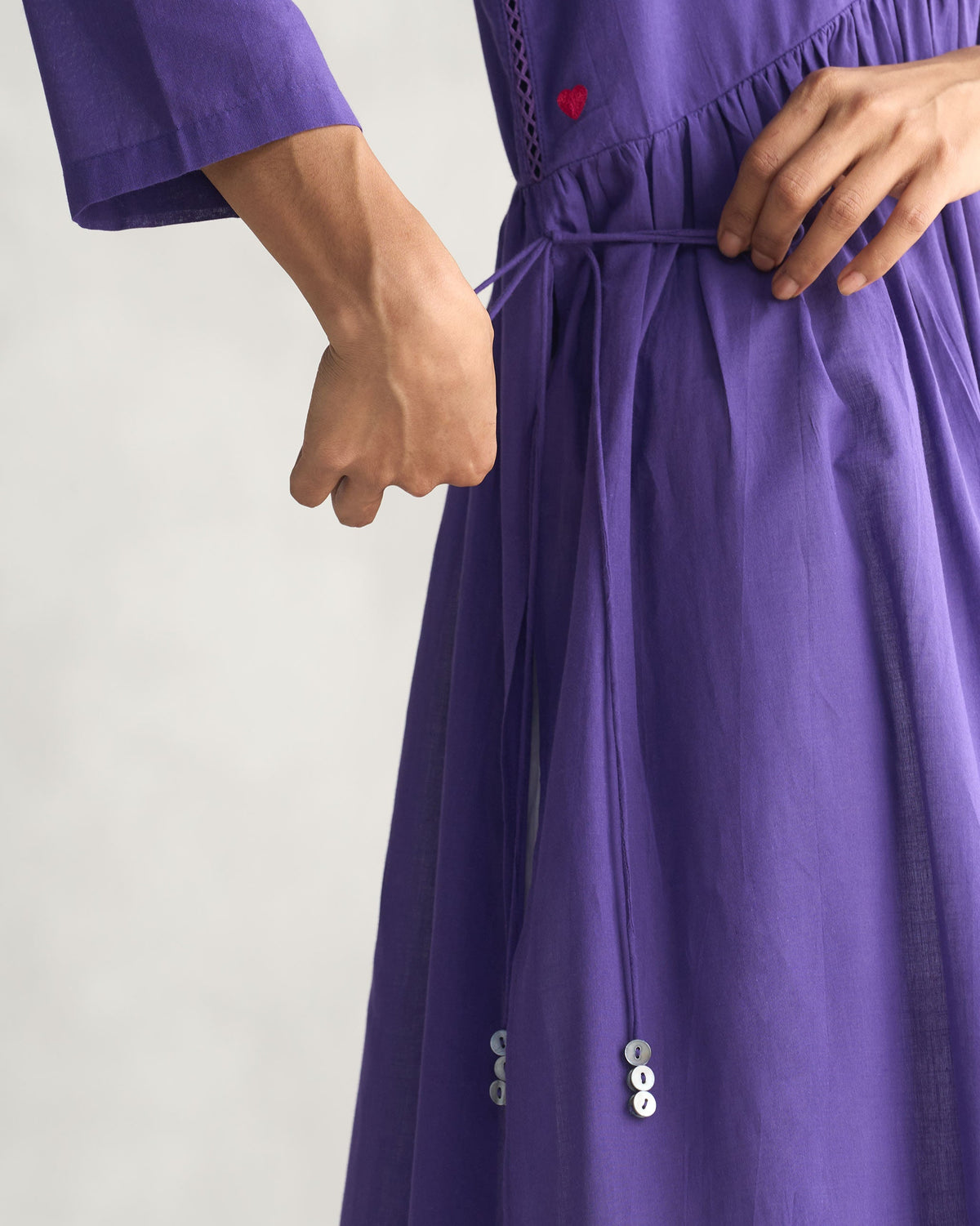 Close-up of purple Waist Gathered Kurta showing its waist tie and small red heart.