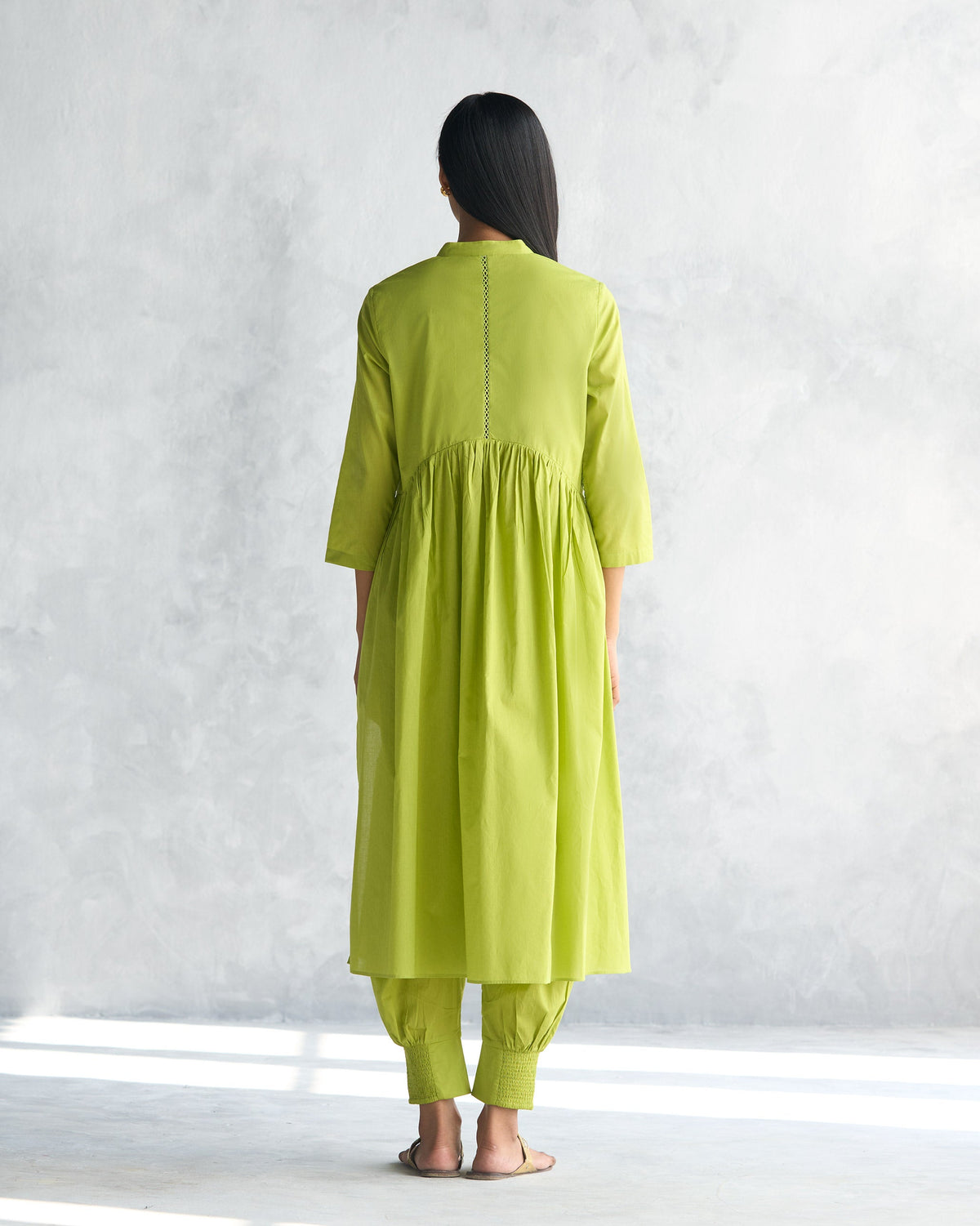 Back of a lime waist gathered kurta with gathers below the yoke worn by a person.