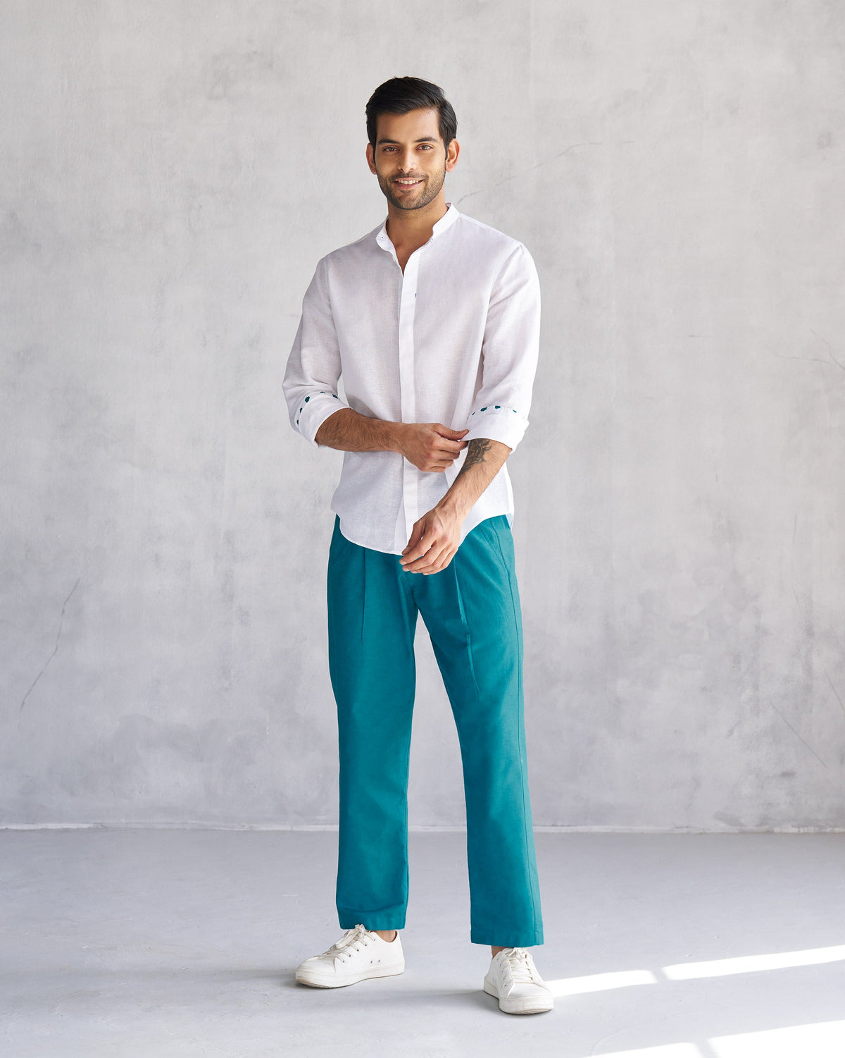 Person wearing a white Riverston shirt with sleeves rolled up.