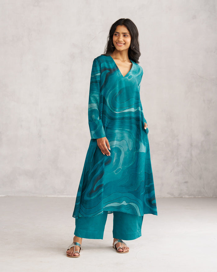 Person wearing a teal V-Neck Flare Kurta with a swirl print.
