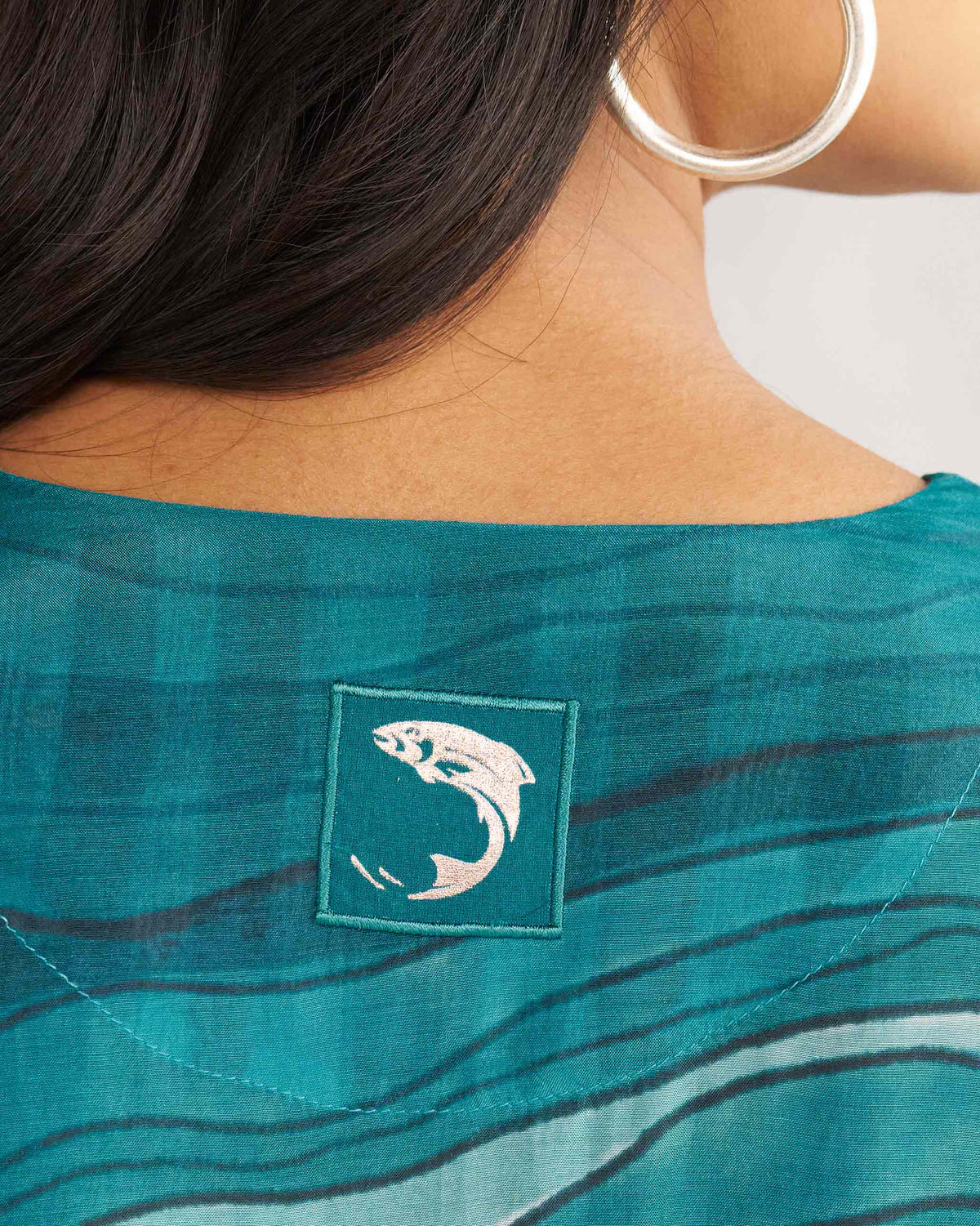 Close-up of the back neck of a teal V-Neck Flare Kurta with a fish patch.