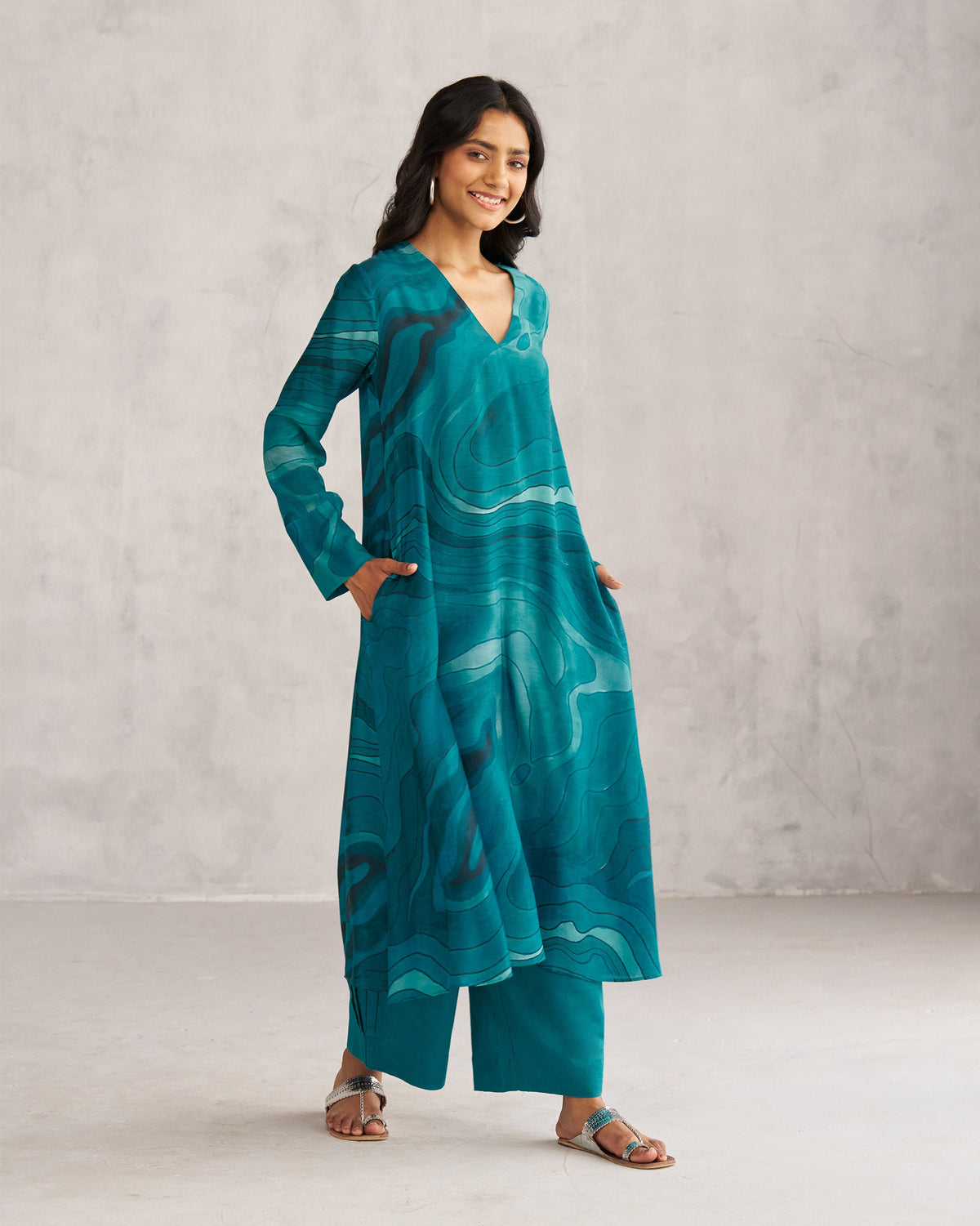 Person wearing a teal V-Neck Flare Kurta with side pockets.
