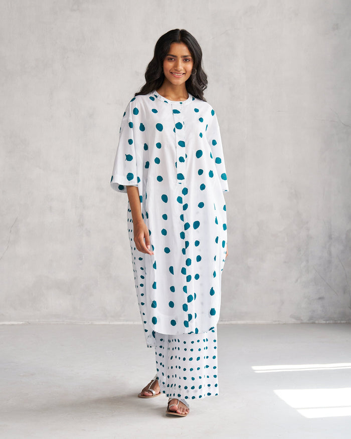 Person wearing a white Boba panelled kurta with teal dots.