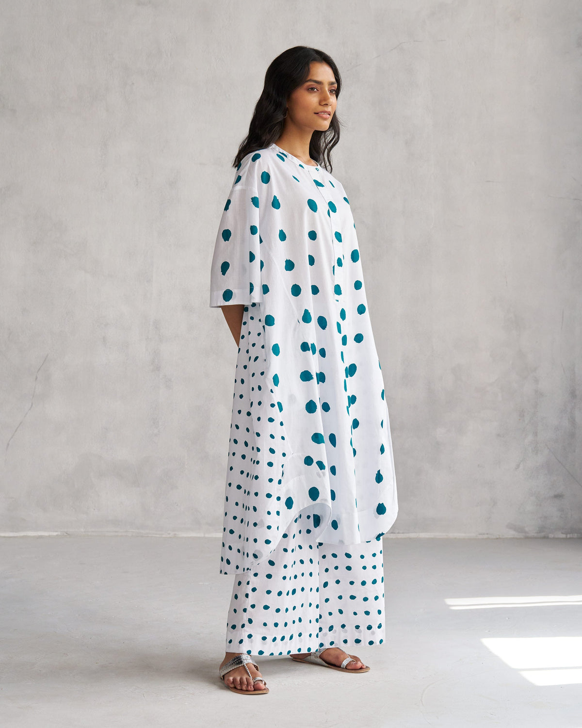 Side view of a white Boba panelled kurta with teal dots worn by a person.