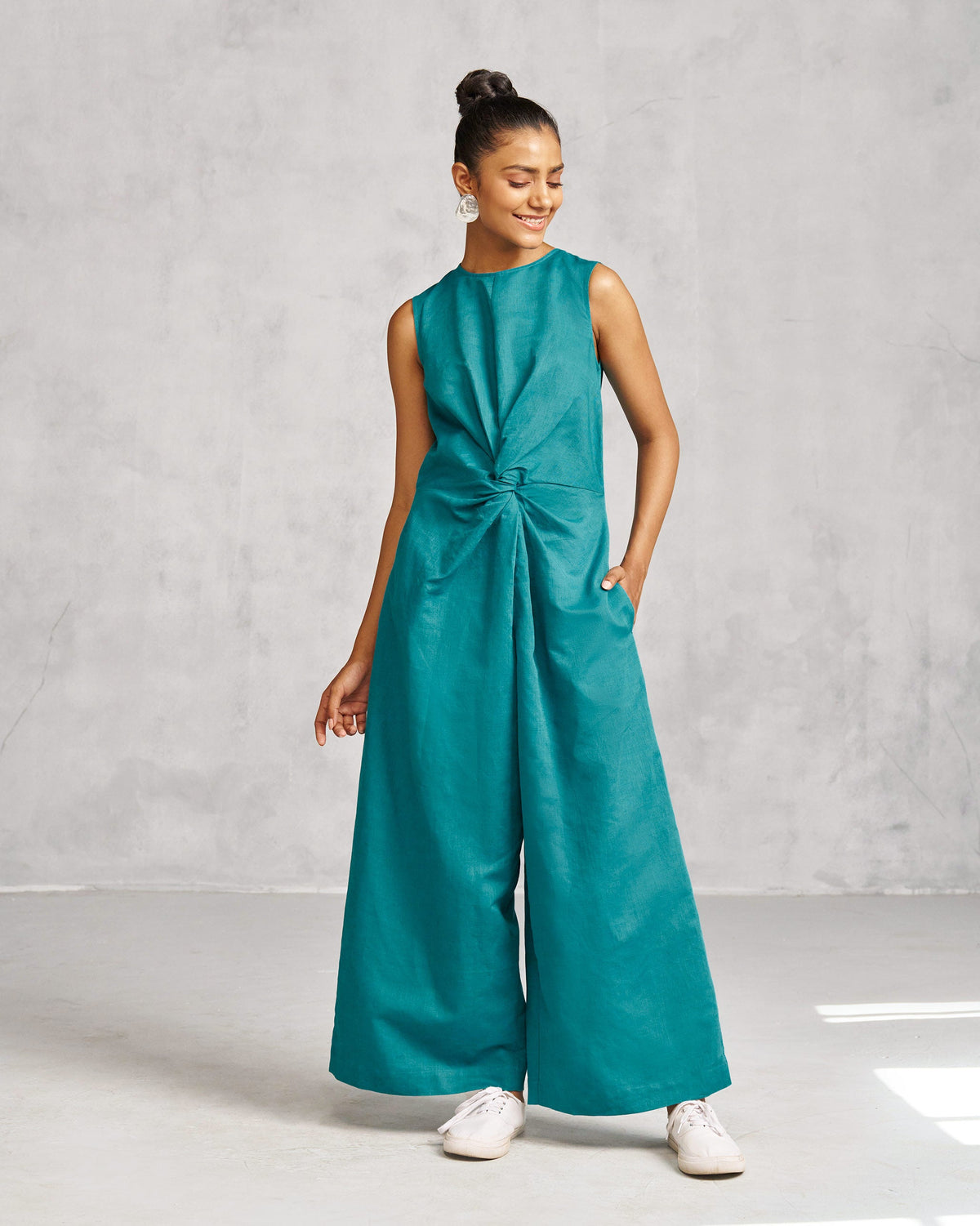 Person wearing the Front Knot Jumpsuit in teal with a knot at the waist.